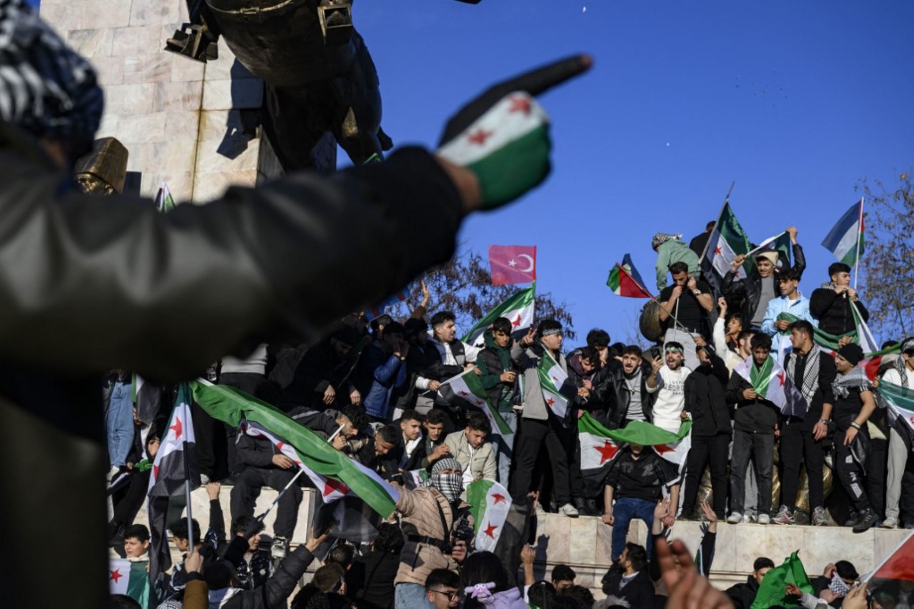 Los residentes sirios en Turquía ondean las banderas de la oposición siria mientras celebran la caída del gobernante de larga data Bashar al-Assad después de que los combatientes rebeldes tomaran el control de la capital siria Damasco durante la noche, en Estambul el 8 de diciembre de 2024. El ministro de Relaciones Exteriores de Turquía dijo el 8 de diciembre de 2024 que el país quería ayudar a "garantizar la seguridad" en Siria después de la caída del presidente Bashar al-Assad frente a una ofensiva de lo