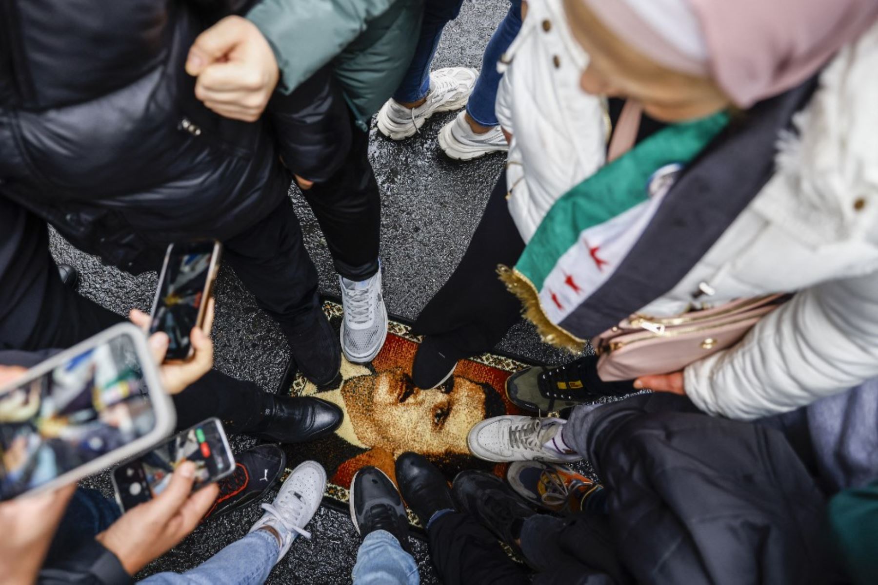 Los manifestantes pisotean una alfombra con un diseño que muestra al presidente Bashar al-Assad durante una protesta fuera del consulado sirio en Estambul el 8 de diciembre de 2024. La capital de Siria se despertó el 8 de diciembre de 2024 con cantos, aplausos y disparos en celebración de la caída del presidente Bashar al-Assad, después de que los rebeldes dijeran que entraron en la ciudad y derrocaron al gobernante de toda la gata. El grupo rebelde Hayat Tahrir al-Sham y las facciones aliadas han presionad