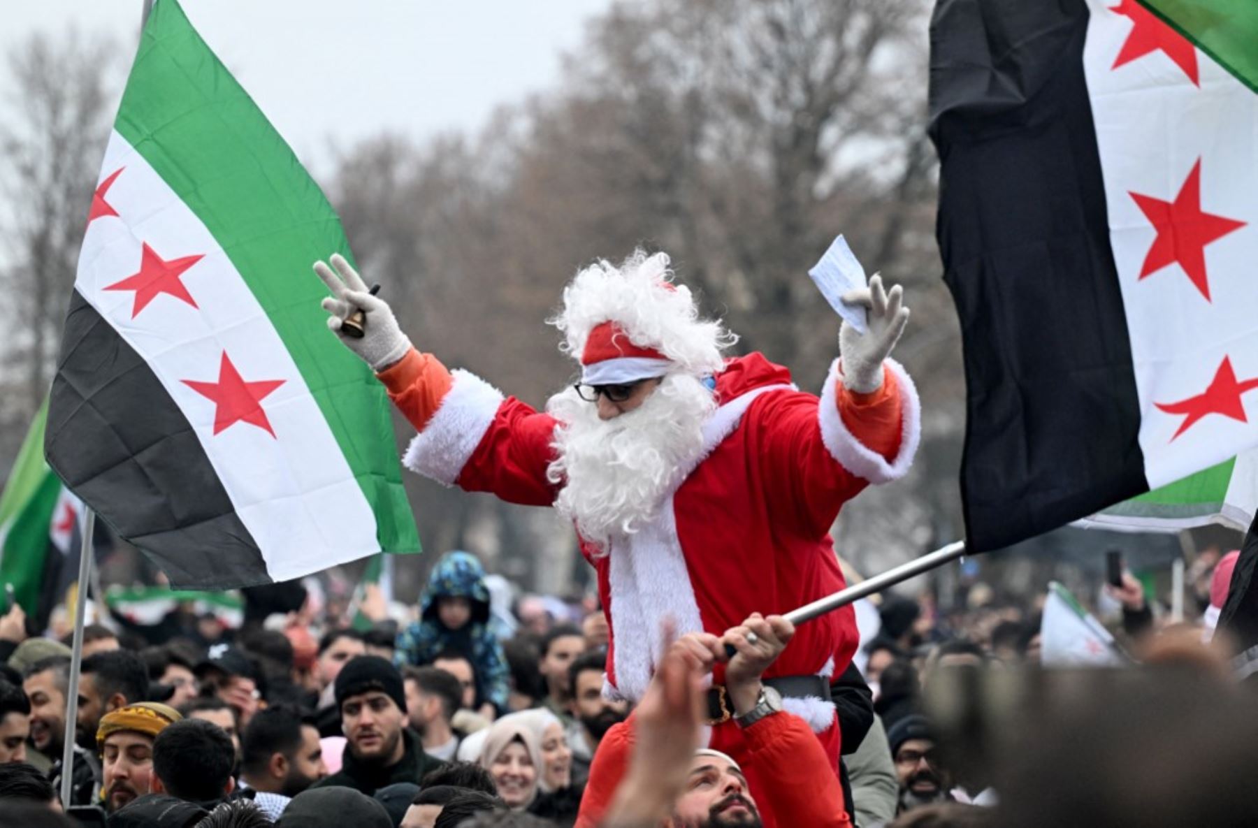 Uno de los manifestantes está vestido de Papá Noel como miembros del mitin de la comunidad siria el 8 de diciembre de 2024 en Berlín, Alemania, para celebrar el fin del gobierno del dictador sirio Bashar al-Assad después de que los combatientes rebeldes tomaran el control de la capital siria Damasco durante la noche. Los rebeldes liderados por los islamistas derrocaron al antiguo gobernante de Siria, Bashar al-Assad, en una ofensiva relámpago que un enviado de la ONU llamó "un momento divisorio" para la nac