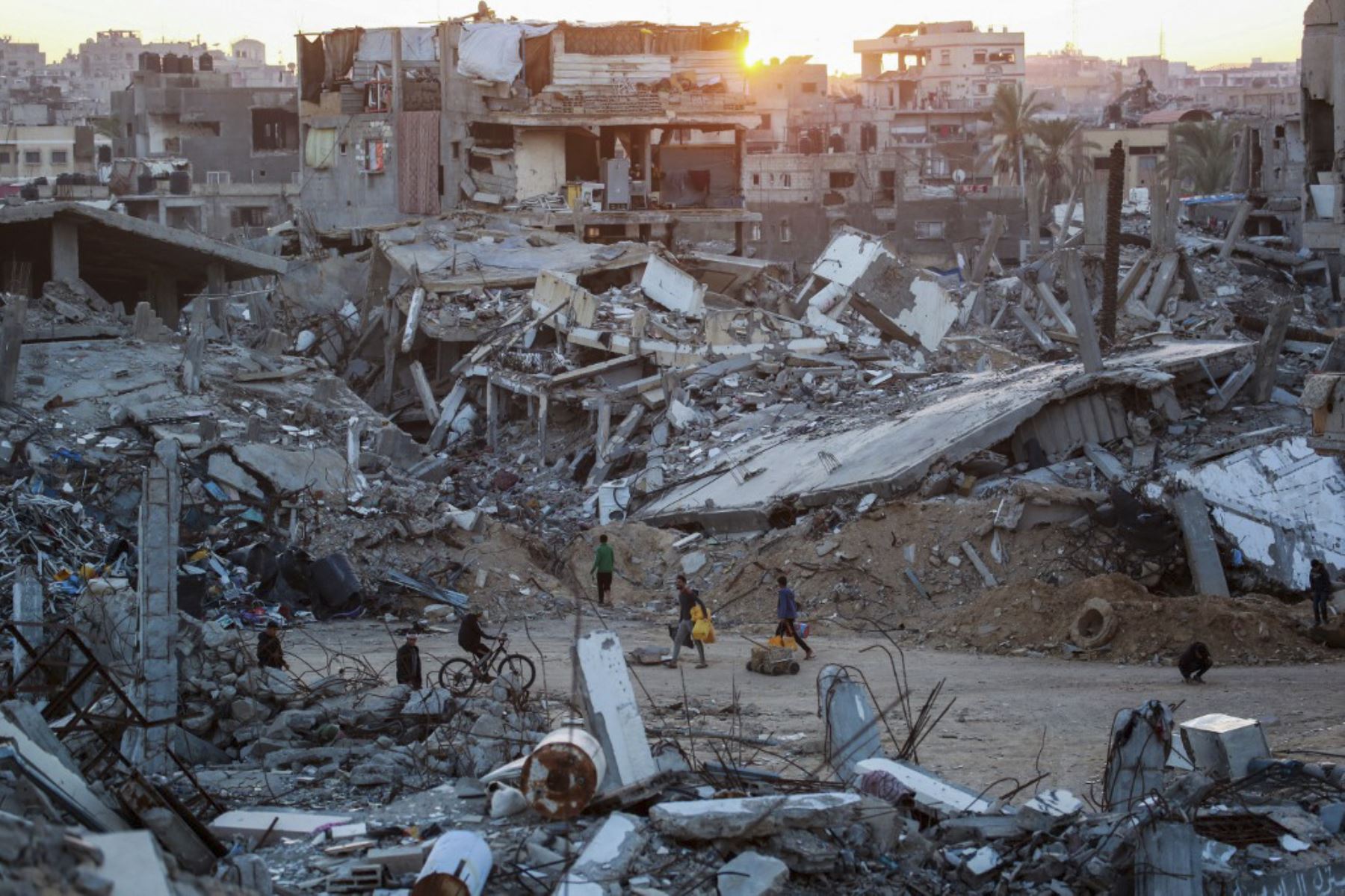 Los palestinos caminan en un barrio devastado debido a los ataques israelíes en la ciudad de Khan Yunis, al sur de la Franja de Gaza, el 2 de diciembre de 2024, en medio de la guerra en curso entre Israel y el movimiento palestino de Hamas. (Foto de Bashar TALEB / AFP)