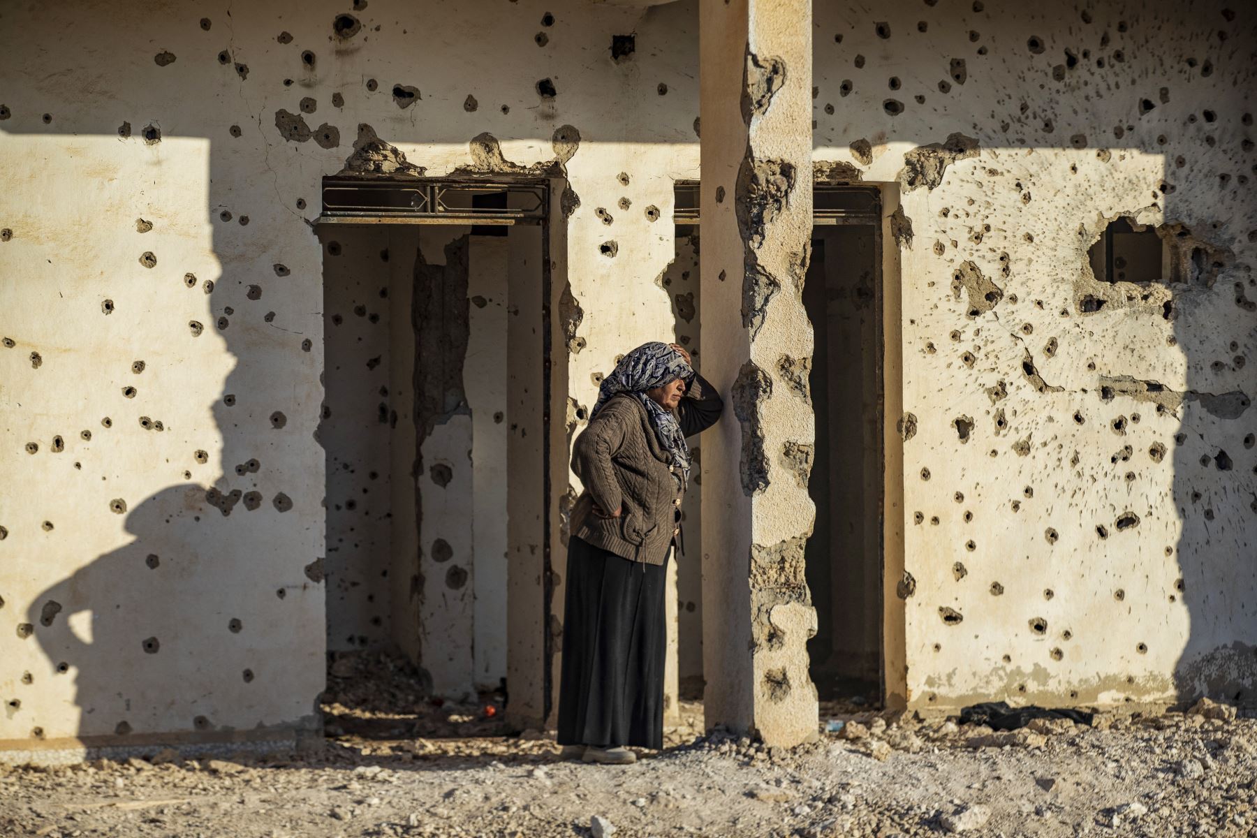 Una mujer kurda siria, que huye del norte de Alepo, se apoya en un muro plagado de balas al llegar a Tabqa, en las afueras occidentales de Raqa, el 4 de diciembre de 2024. Las fuerzas del gobierno sirio lanzaron un contraataque contra los rebeldes liderados por islamistas alrededor de la ciudad clave de Hama el 4 de diciembre después de sufrir una serie de pérdidas asombrosas, dijo un monitor de guerra. Foto: AFP