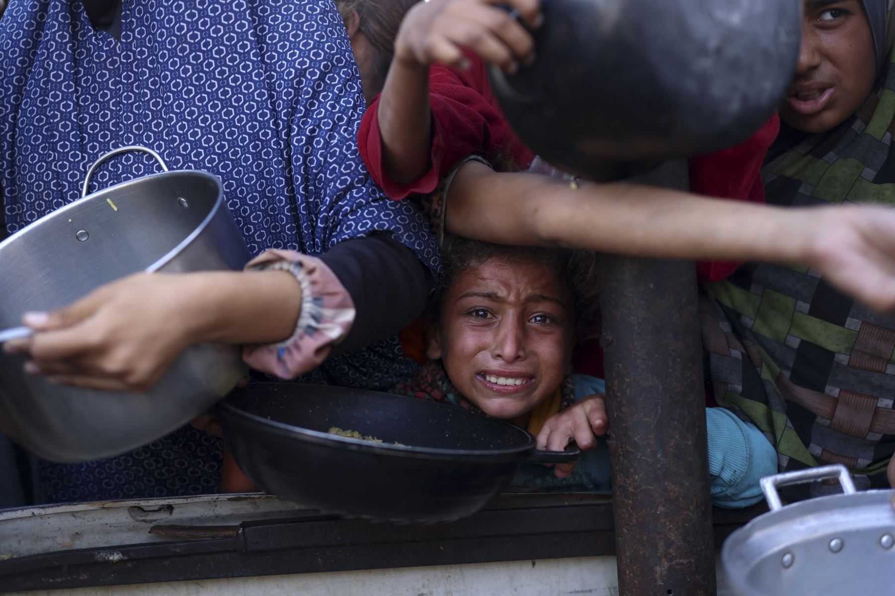 Una niña palestina espera en una cola para recibir comida fuera de un centro de distribución al sur de Khan Yunis el 6 de diciembre de 2024, en medio de la guerra en curso entre Israel y Hamas. (Foto de BASHAR TALEB / AFP)