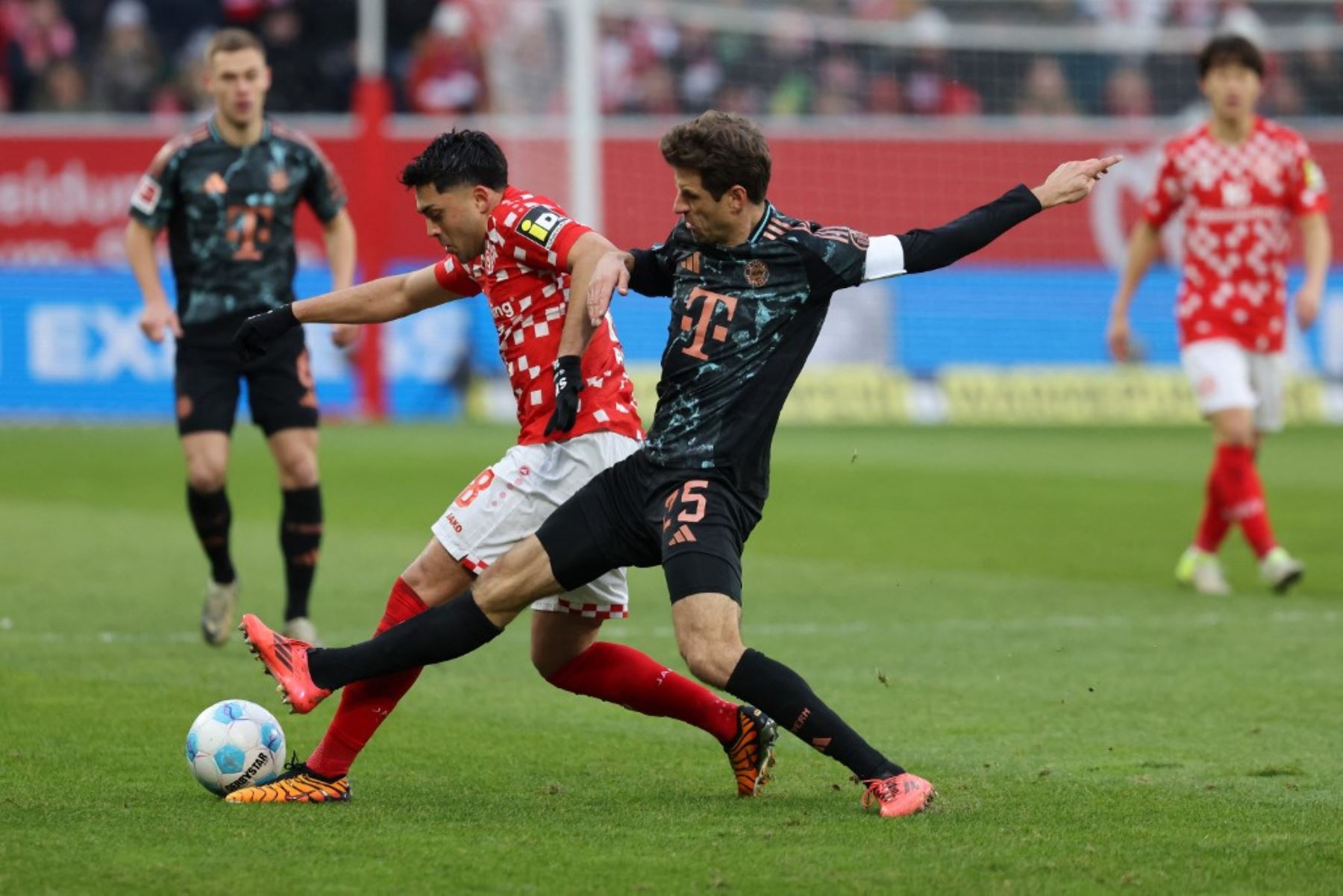 El centrocampista alemán #18 del Mainz, Nadiem Amiri (L), y el delantero alemán #25 del Bayern Munich, Thomas Mueller, compiten por el balón durante el partido de fútbol de la Bundesliga de la primera división alemana entre 1 FSV Mainz 05 y el FC Bayern Munich en Mainz, oeste de Alemania, el 14 de diciembre de 2024. (Foto de Daniel ROLAND / AFP)