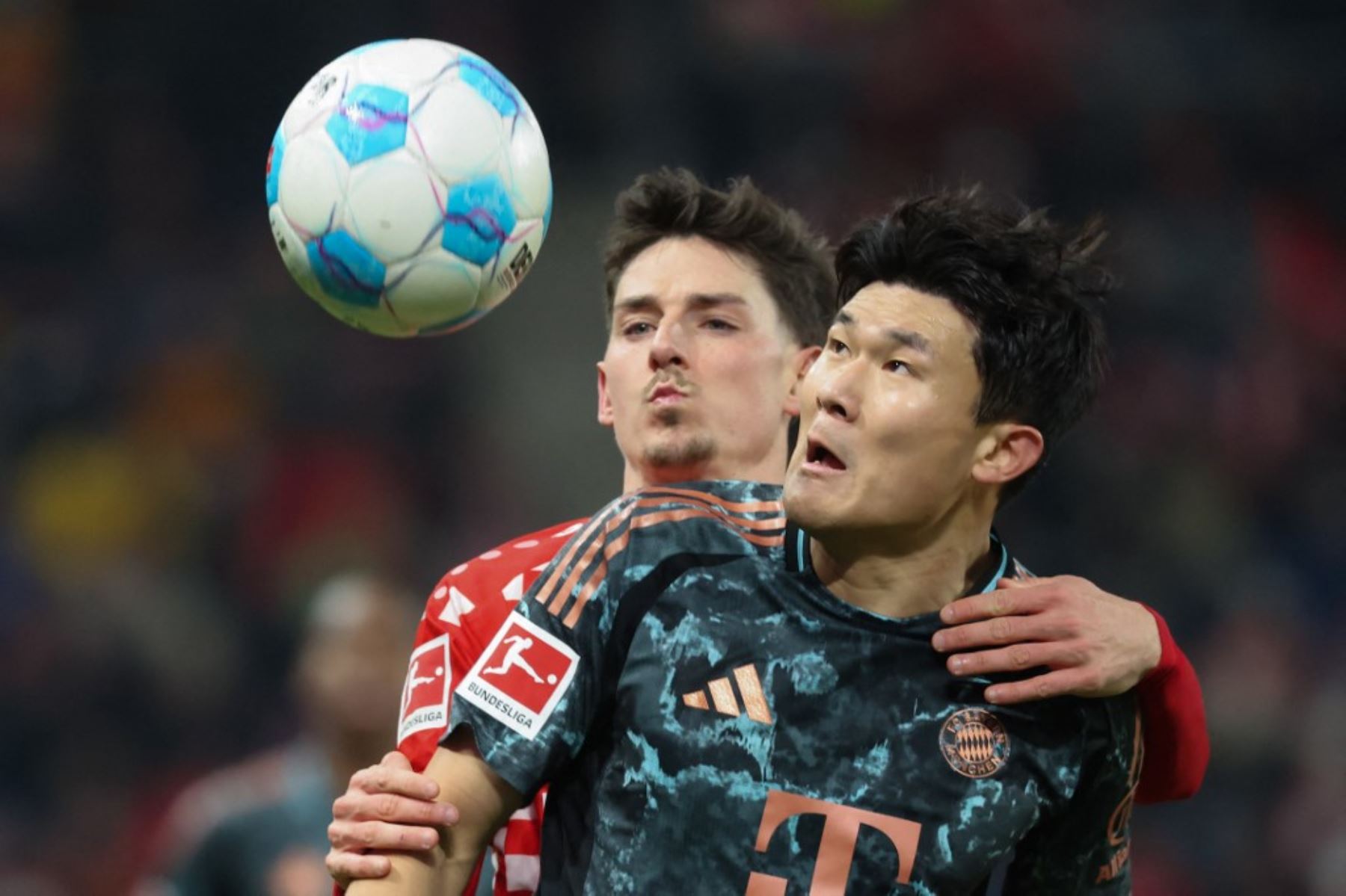 El defensor surcoreano del Bayern de Múnich #03 Kim†Min-Jae (R) y el defensor francés del Mainz #19 Anthony Caci compiten por el balón durante el partido de fútbol de la Bundesliga de primera división alemana entre 1 FSV Mainz 05 y FC Bayern Munich en Mainz, oeste de Alemania el 14 de diciembre de 2024. (Foto de Daniel ROLAND / AFP)