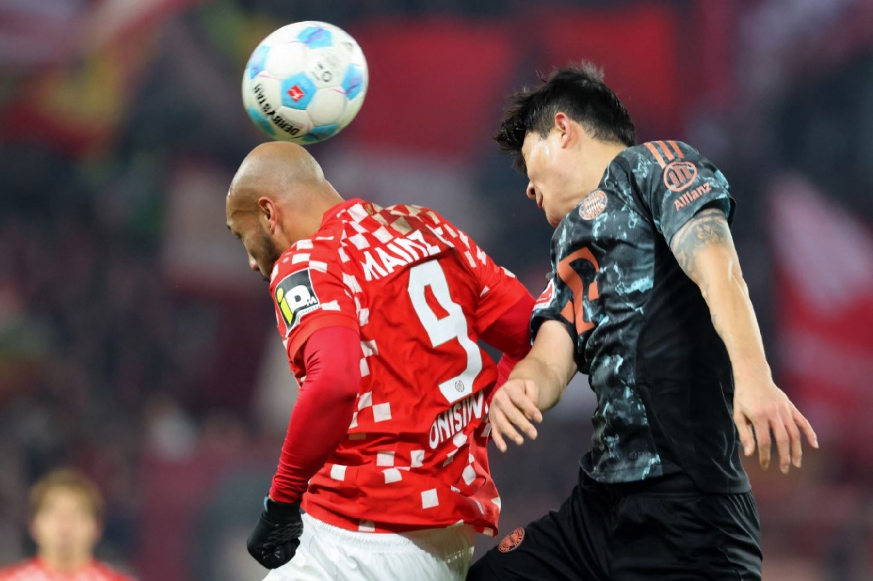 El defensa surcoreano del Bayern de Múnich #03 Kim†Min-Jae (R) y el delantero austriaco del Mainz #09 Karim Onisiwo saltan por el balón durante el partido de fútbol de la Bundesliga de primera división alemana entre 1 FSV Mainz 05 y FC Bayern Munich en Mainz, oeste de Alemania, el 14 de diciembre de 2024. (Foto de Daniel ROLAND / AFP)