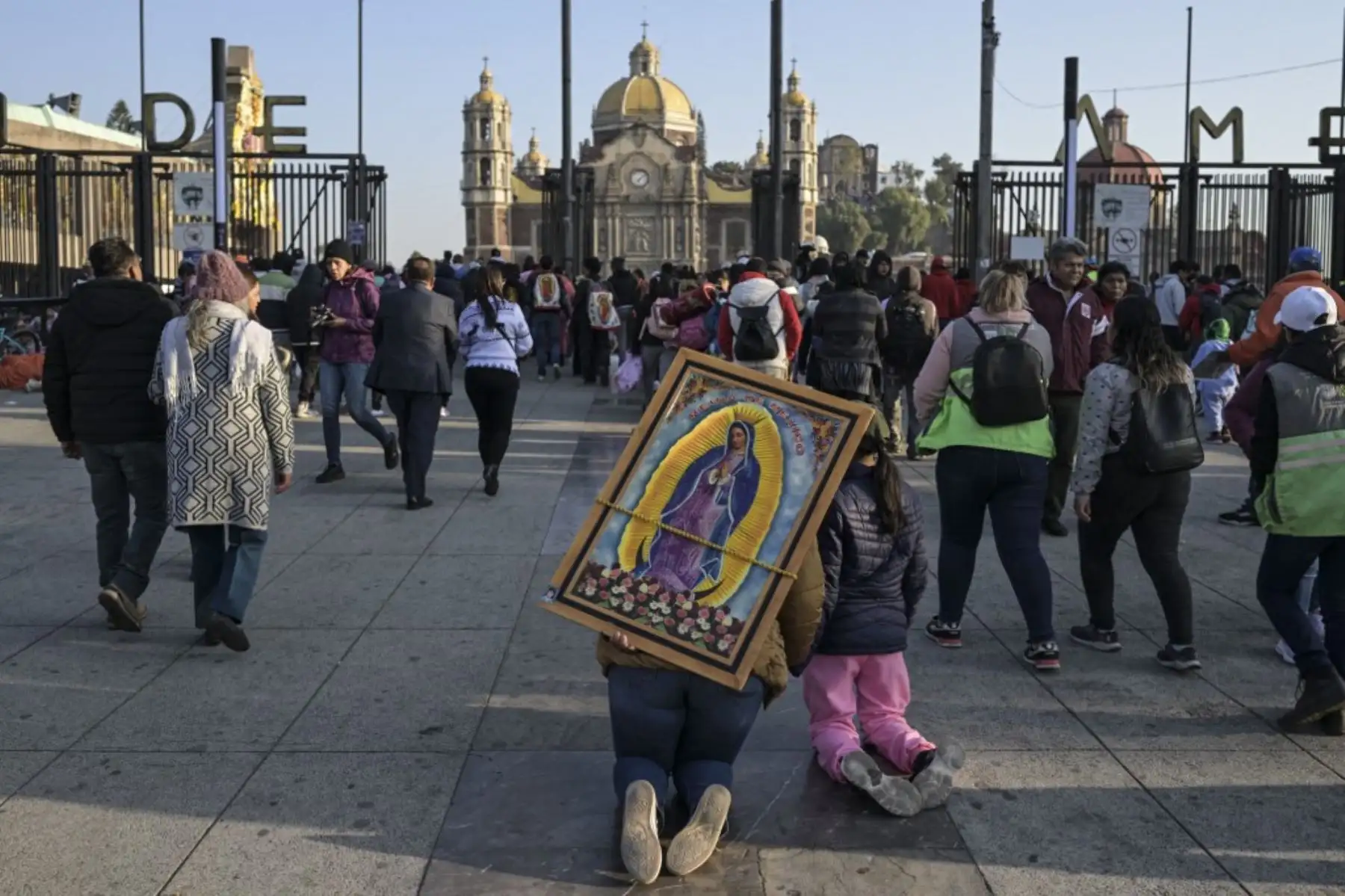 Una penitente católica que lleva una imagen de la Virgen de Guadalupe llega de rodillas para participar en la conmemoración del día de la Virgen en la Basílica de Guadalupe en la Ciudad de México el 12 de diciembre de 2024. (Foto de Yuri CORTEZ / AFP)