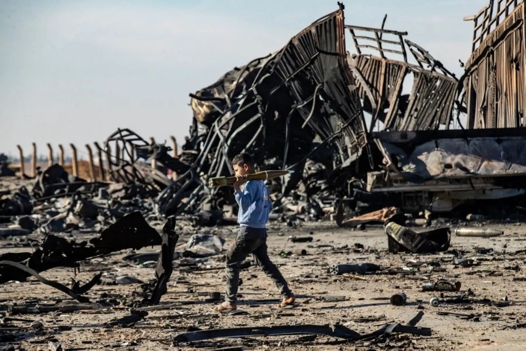Un niño lleva una granada propulsada por cohetes (RPG) sin explotar en el sitio del ataque aéreo israelí de la noche anterior que apuntó a envíos de armas que pertenecían a las fuerzas del gobierno sirio en Qamishli, principalmente en el noreste kurdo de Siria, el 10 de diciembre de 2024. El enviado especial de la ONU para Siria pidió a Israel el 10 de diciembre que detuviera sus movimientos militares y bombardeos en Siria, después de que un monitor de guerra informara de 300 ataques aéreos desde la caída d