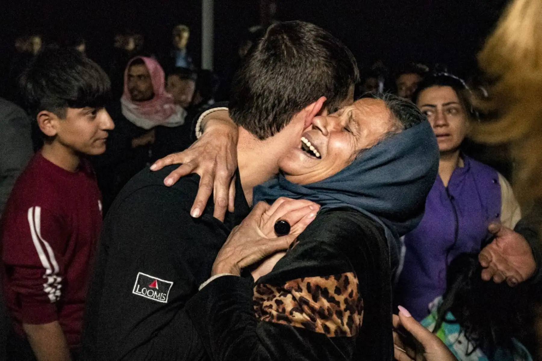 Una mujer reacciona mientras abraza a un hombre mientras los familiares saludan a antiguos prisioneros liberados por la administración kurda siria después de que se emitiera una amnistía general, en Qamishli, en el noreste de Siria, el 12 de diciembre de 2024. Los rebeldes liderados por islamistas tomaron la capital siria Damasco en una ofensiva relámpago el 8 de diciembre, derrocando al presidente Bashar al-Assad y poniendo fin a cinco décadas de gobierno de Baath en el país. (Foto de Delil SOULEIMAN / AFP