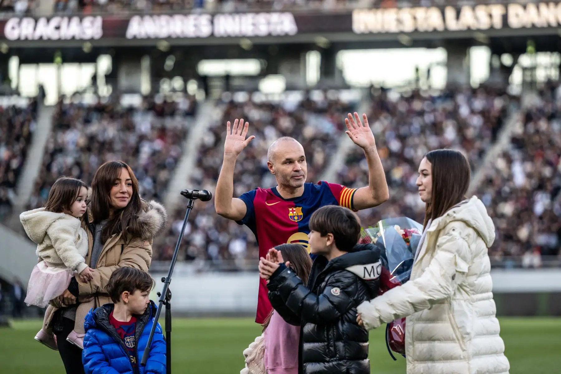 La leyenda del fútbol español Andrés Iniesta  hace gestos mientras lo acompañan su esposa Anna Ortiz y sus cinco hijos durante la ceremonia de su retiro después del partido de fútbol de exhibición entre los ex jugadores del Barcelona y el Real Madrid (Barca Legends y Real Madrid Leyendas) en Ajinomoto, estadio de Tokio.
Foto: AFP