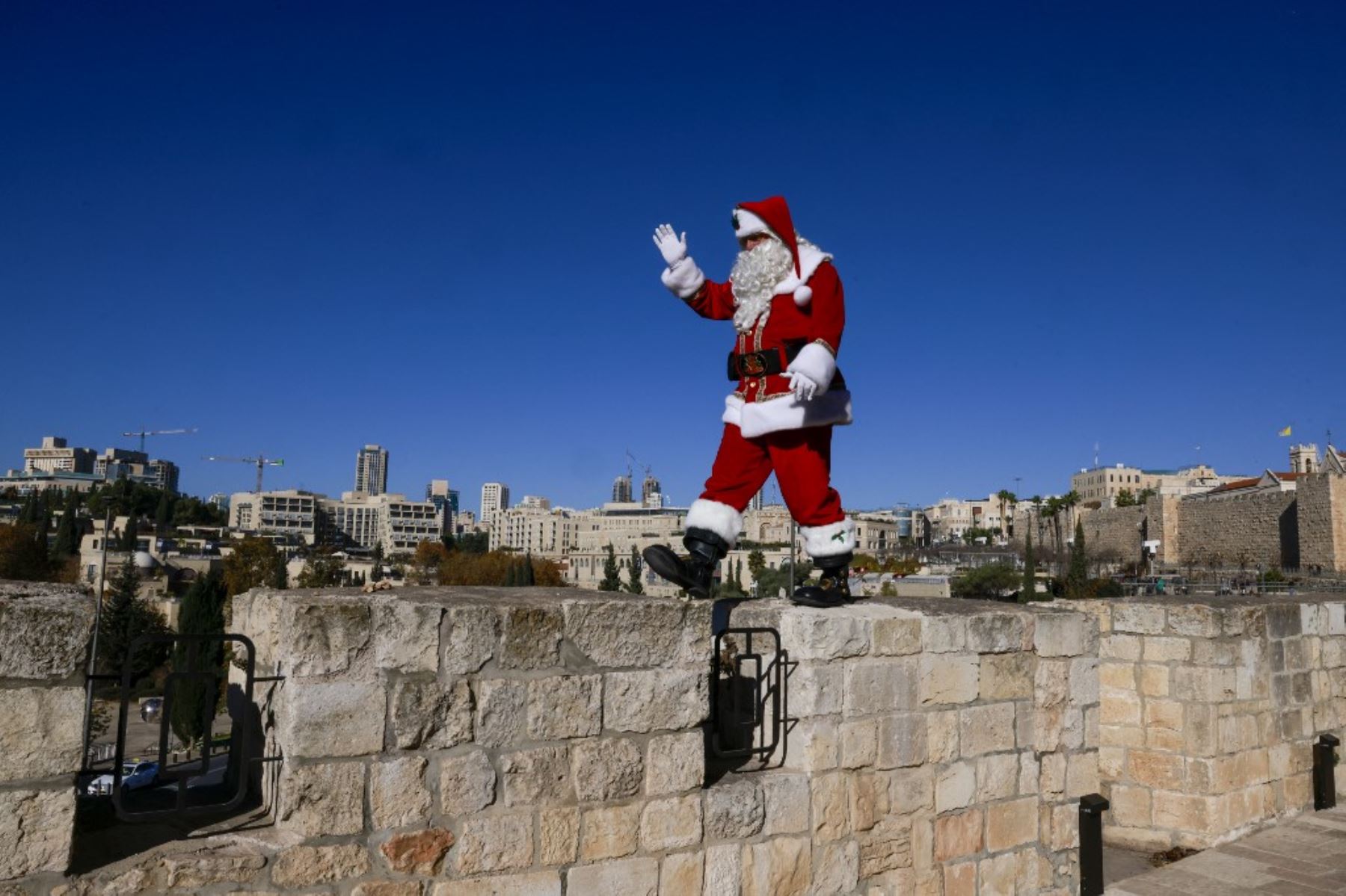 El palestino Issa Kassissieh, vestido de Papá Noel, posa para una foto en la Puerta de Jaffa en la Ciudad Vieja de Jerusalén el 19 de diciembre de 2024, antes de las celebraciones por Navidad. Foto: AFP