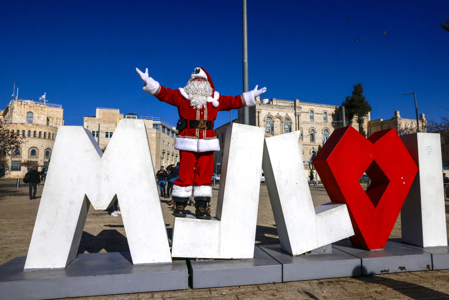 El palestino Issa Kassissieh, vestido de Papá Noel, posa para una foto en la Puerta de Jaffa en la Ciudad Vieja de Jerusalén el 19 de diciembre de 2024, antes de las próximas celebraciones por Navidad. Foto: AFP