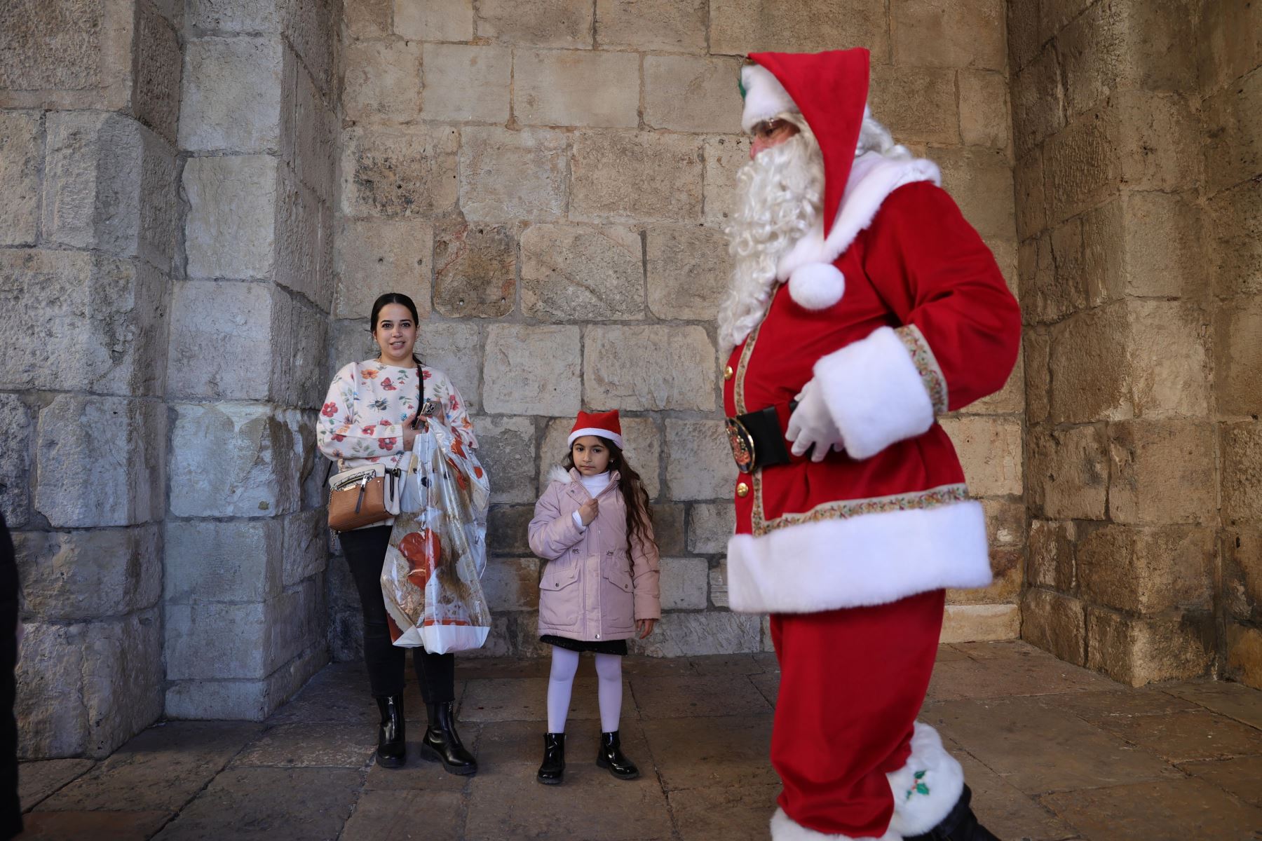 Issa Kassissieh, vestido como Papá Noel, pasea junto a los transeúntes cerca de la Puerta de Jaffa en la Ciudad Vieja de Jerusalén, el 19 de diciembre de 2024, antes de las vacaciones de Navidad. Foto: EFE