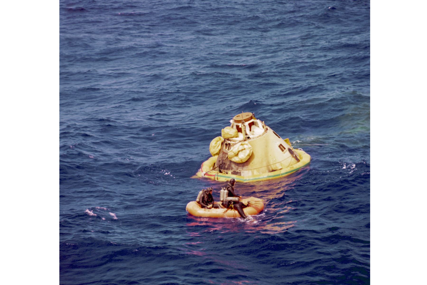 Los hombres rana de la Marina de los EE. UU. preparan el módulo de comando del Apolo 8 para izarlo a bordo del USS Yorktown en el Pacífico, al noroeste de las islas hawaianas, el 27 de diciembre de 1968, después de su aterrizaje. La nave espacial completó un vuelo impecable con un aterrizaje preciso, a sólo tres millas de la nave de recuperación. Los astronautas del Apolo 8 fueron el comandante de la nave espacial Frank Borman, el piloto del módulo de comando James Lovell y el piloto del módulo lunar Willia