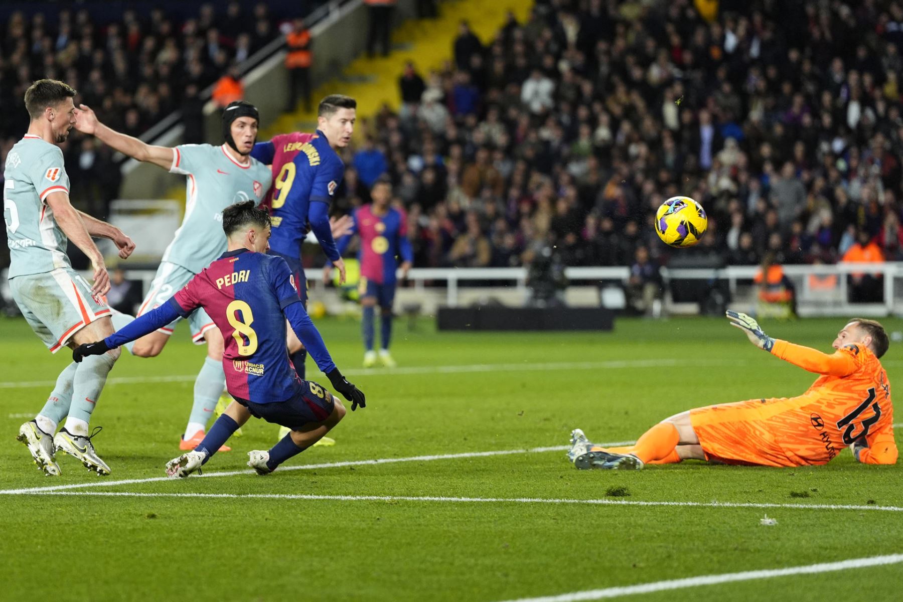 El centrocampista del FC Barcelona Pedri (3i) remata a puerta durante el partido de la jornada 18 de LaLiga entre el FC Barcelona y el Atlético de Madrid, este sábado en el estadio olímpico Lluis Companys. EFE/ Siu Wu