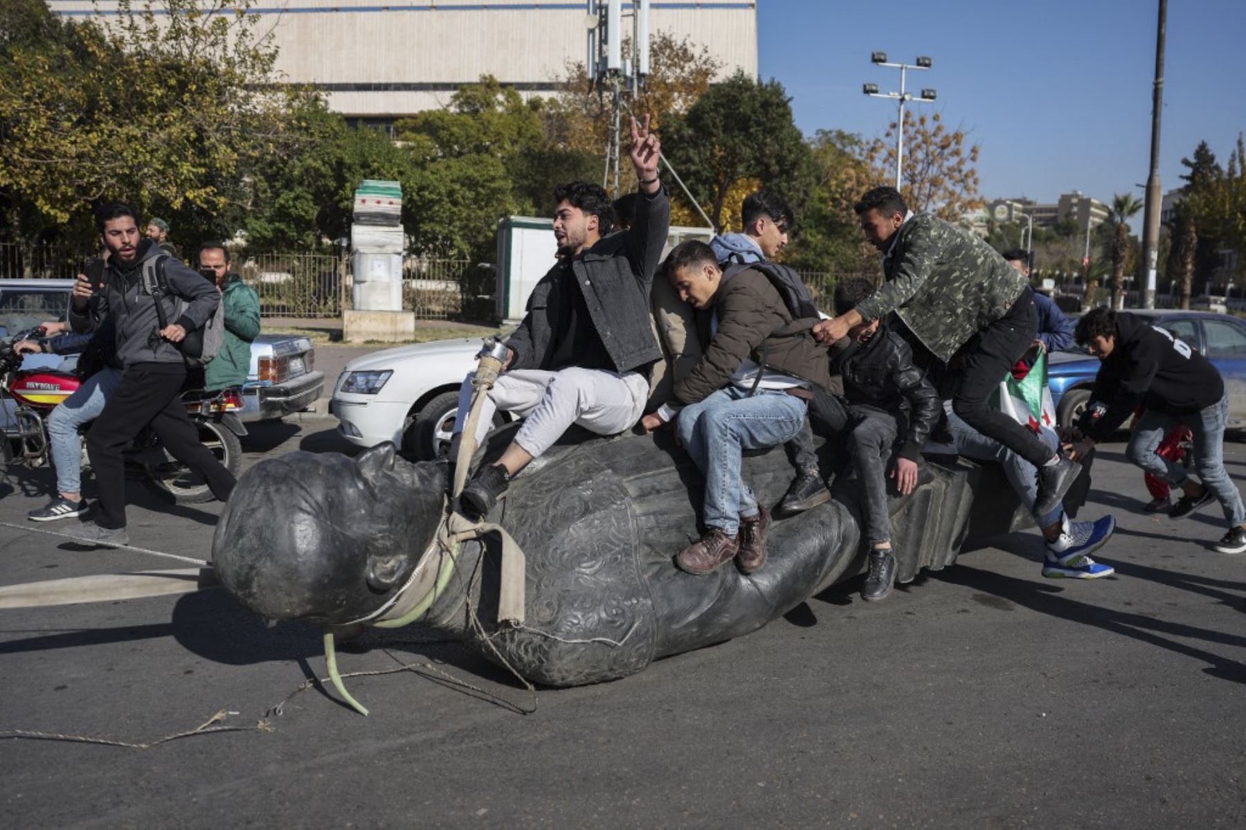 Los estudiantes arrastran una estatua derrocada del difunto presidente Hafez al-Assad por la calle durante un mitin cerca del campus de la Universidad de Damasco en la capital siria el 15 de diciembre de 2024. Los rebeldes liderados por islamistas tomaron Damasco en una ofensiva relámpago el 8 de diciembre, derrocando al presidente Bashar al-Assad y poniendo fin a cinco décadas de gobierno de Baath en Siria. (Foto de Omar HAJ KADOUR / AFP)