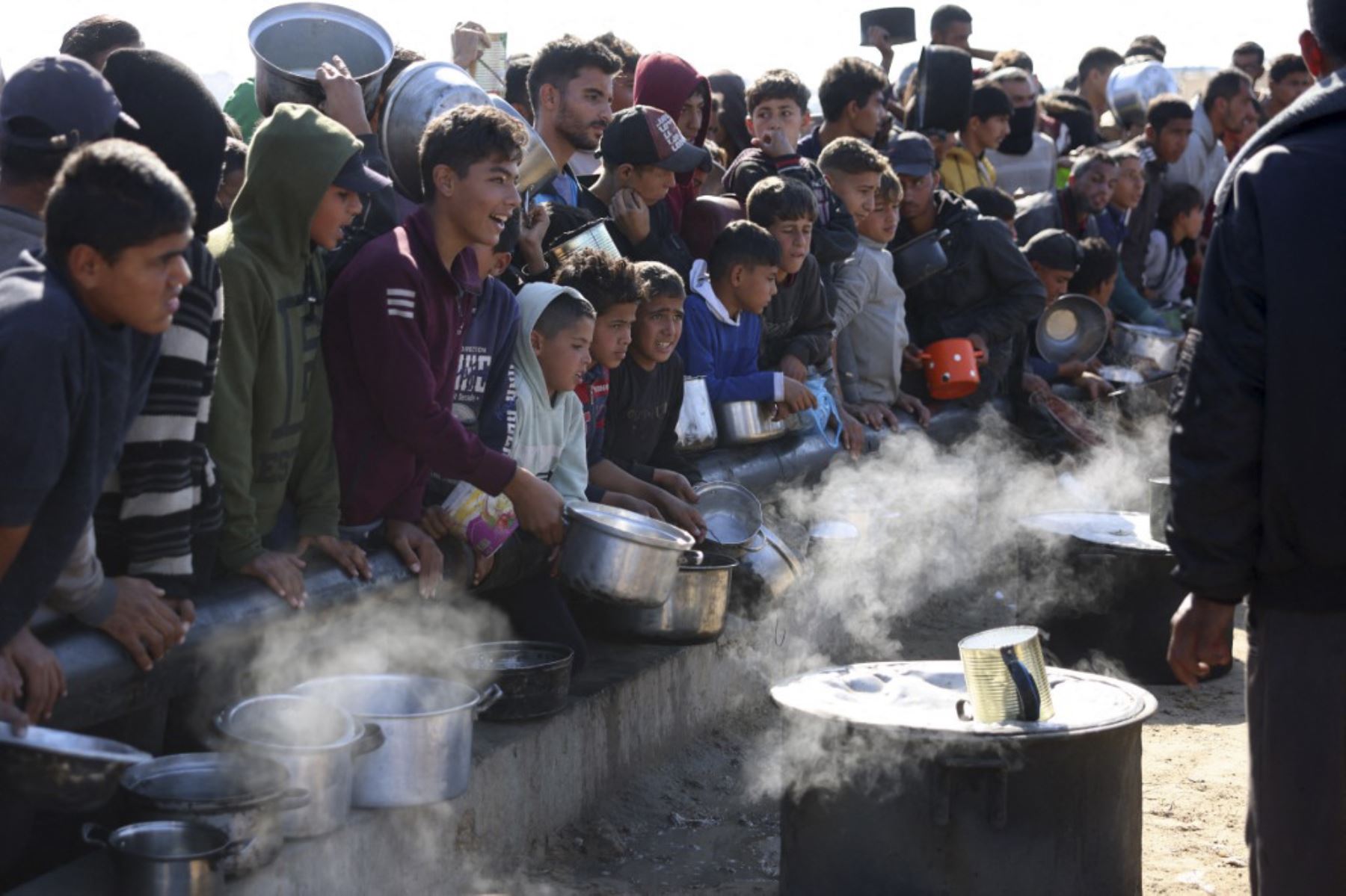 Los palestinos esperan una porción de alimentos en un centro de distribución al sur de Khan Yunis, en el sur de la Franja de Gaza, el 17 de diciembre de 2024, en medio de la guerra en curso entre Israel y el movimiento palestino de Hamas. (Foto de BASHAR TALEB / AFP)