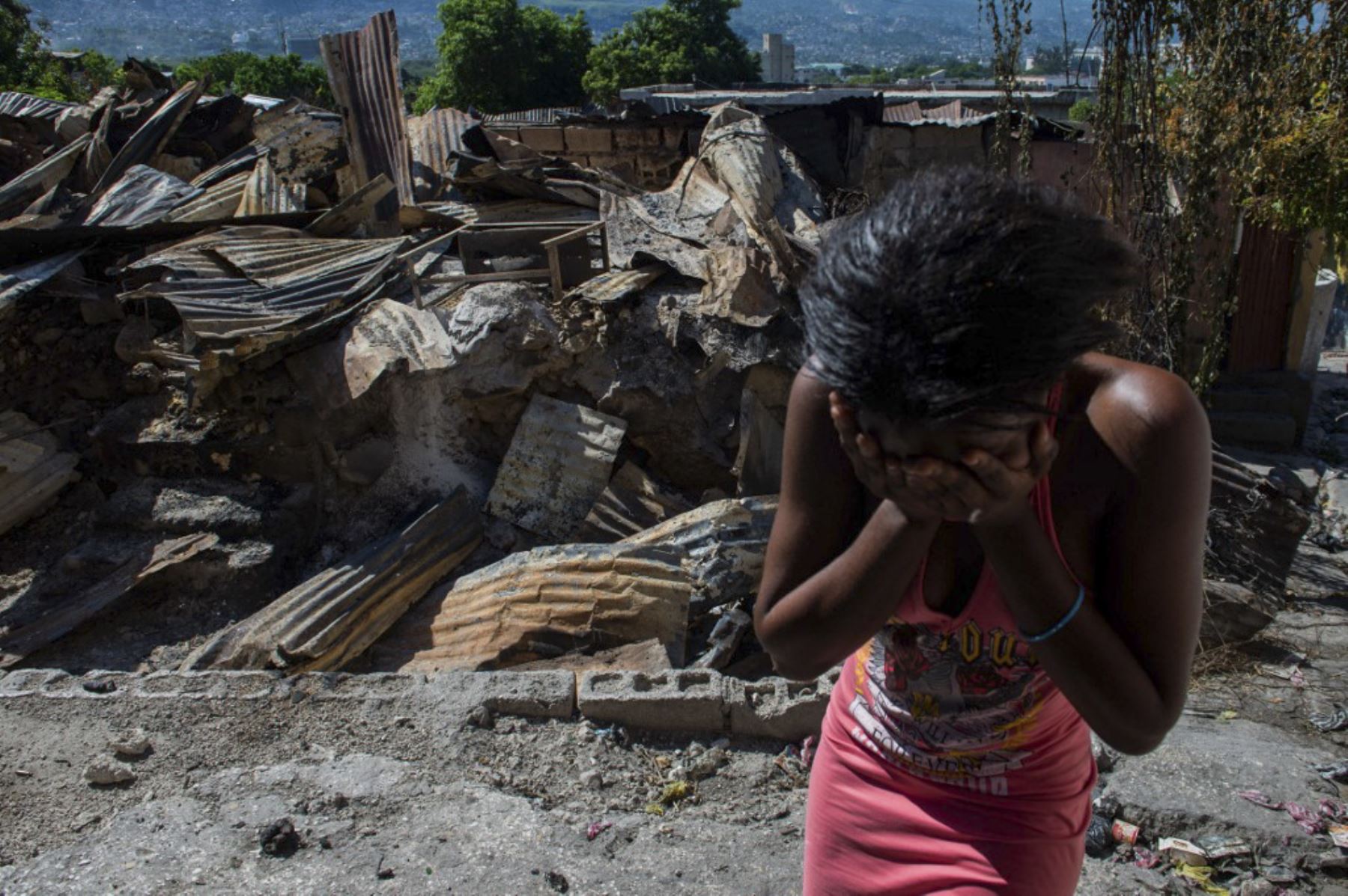 Una mujer llora fuera de su casa después de que pandillas armadas le prendan fuego en el barrio Post Marchand de Port-au-Prince el 17 de diciembre de 2024. (Foto de Clarens SIFFROY / AFP)