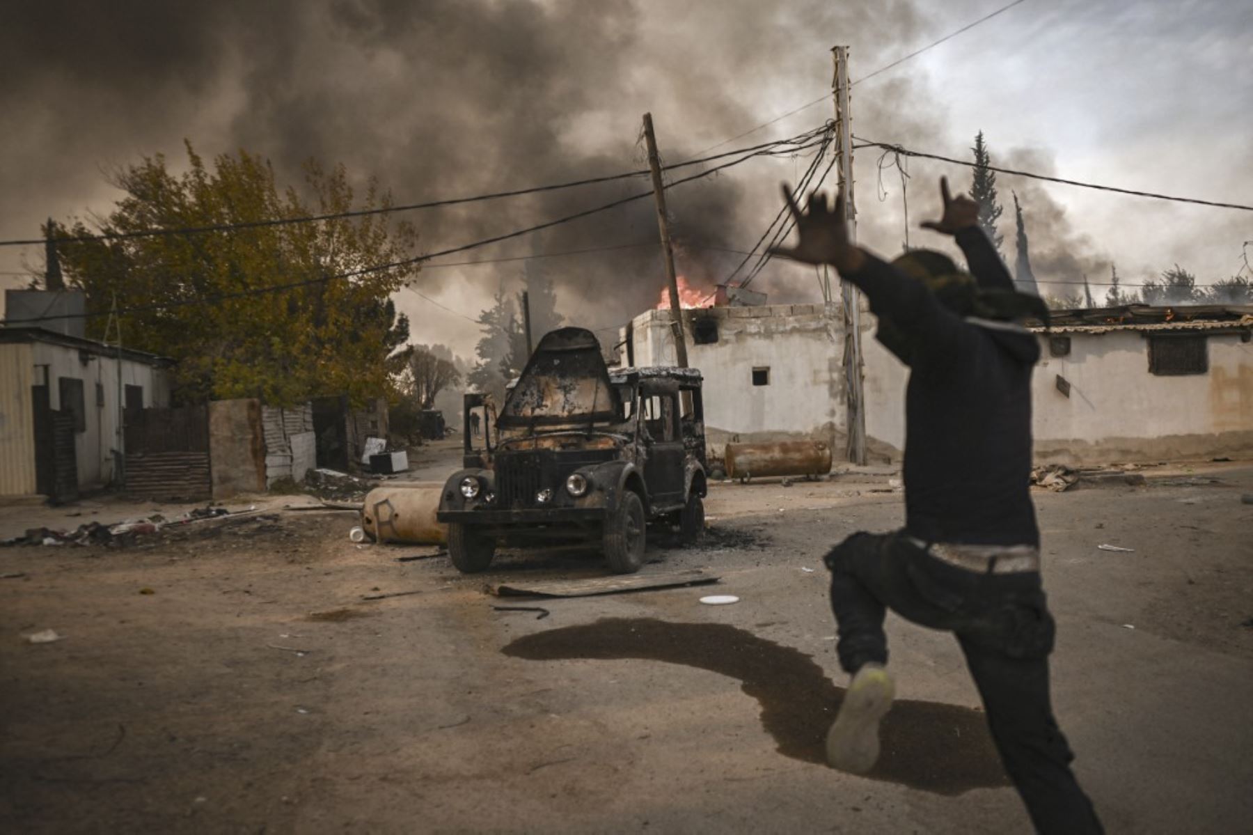 Un hombre hace gestos mientras la gente saquea el complejo de viviendas militares de Najha en el sureste de Damasco el 16 de diciembre de 2024. Los rebeldes liderados por islamistas tomaron Damasco en una ofensiva relámpago el 8 de diciembre, derrocando al presidente Bashar al-Assad y poniendo fin a cinco décadas de gobierno de Baath en Siria. (Foto de Aris MESSINIS / AFP)