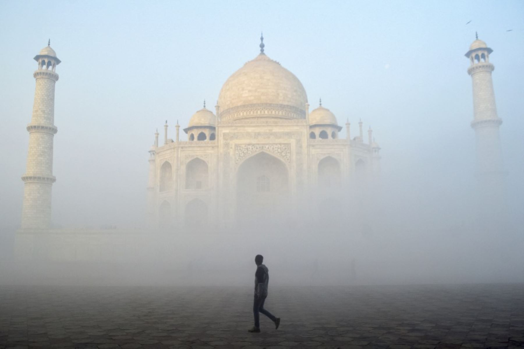 Un hombre pasa por el Taj Mahal en una fría mañana con niebla en Agra el 18 de diciembre de 2024. (Foto de Pawan SHARMA / AFP)