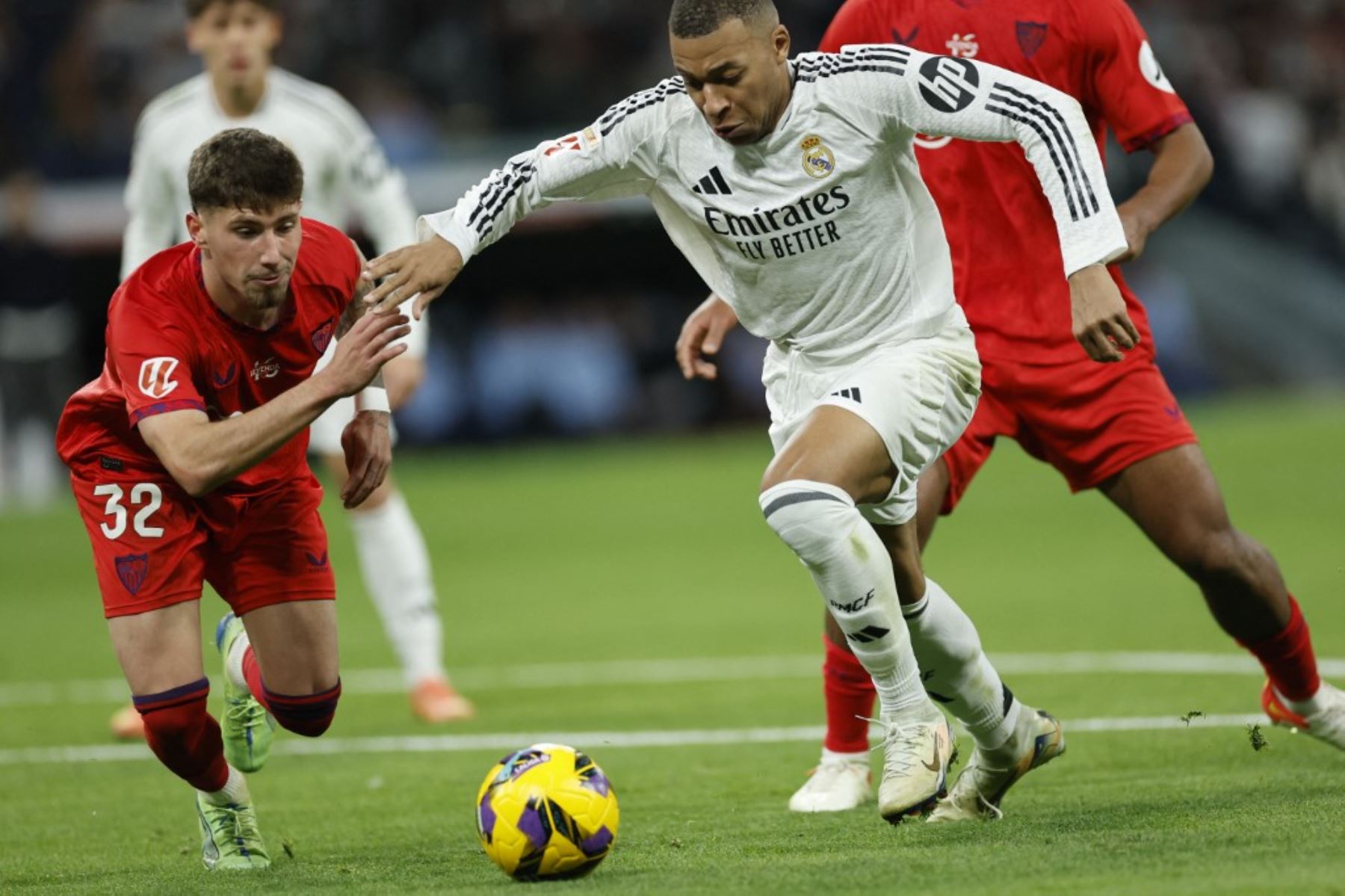 El defensa español del Sevilla #32 José Ángel Carmona y el delantero francés del Real Madrid #09 Kylian Mbappe luchan por el balón durante el partido de fútbol de la liga española entre el Real Madrid CF y el Sevilla FC en el estadio Santiago Bernabéu de Madrid el 22 de diciembre de 2024. (Foto de OSCAR DEL POZO / AFP)