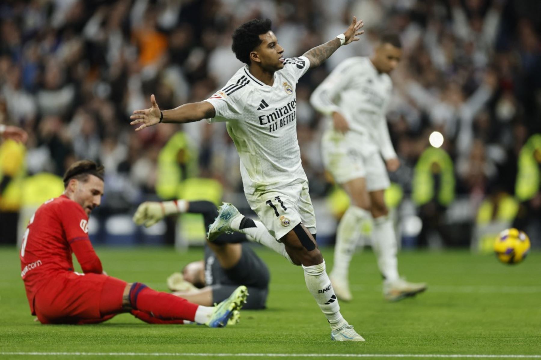 El delantero brasileño #11 del Real Madrid, Rodrygo, celebra el tercer gol de su equipo durante el partido de fútbol de la liga española entre el Real Madrid CF y el Sevilla FC en el estadio Santiago Bernabeu de Madrid el 22 de diciembre de 2024. (Foto de OSCAR DEL POZO / AFP)