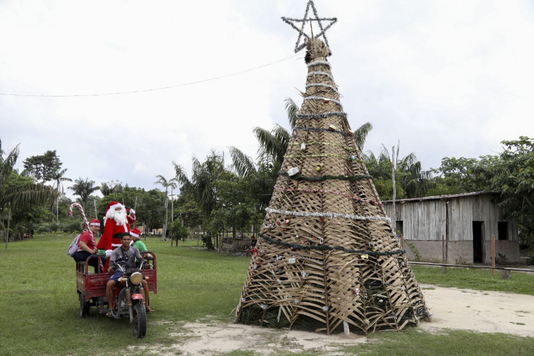 El voluntario Jorge Alberto Barroso, vestido de Papá Noel, es transportado en triciclo para entregar regalos a los niños en la comunidad ribereña de Abelha, en la ciudad de Manaus, estado de Amazonas, norte de Brasil, el 20 de diciembre de 2024. Desde 1998, el grupo "Amigos de Papá Noel" ha estado promoviendo la Navidad para los niños en las comunidades rurales y ribereñas de la selva amazónica. (Foto de MICHAEL DANTAS / AFP)