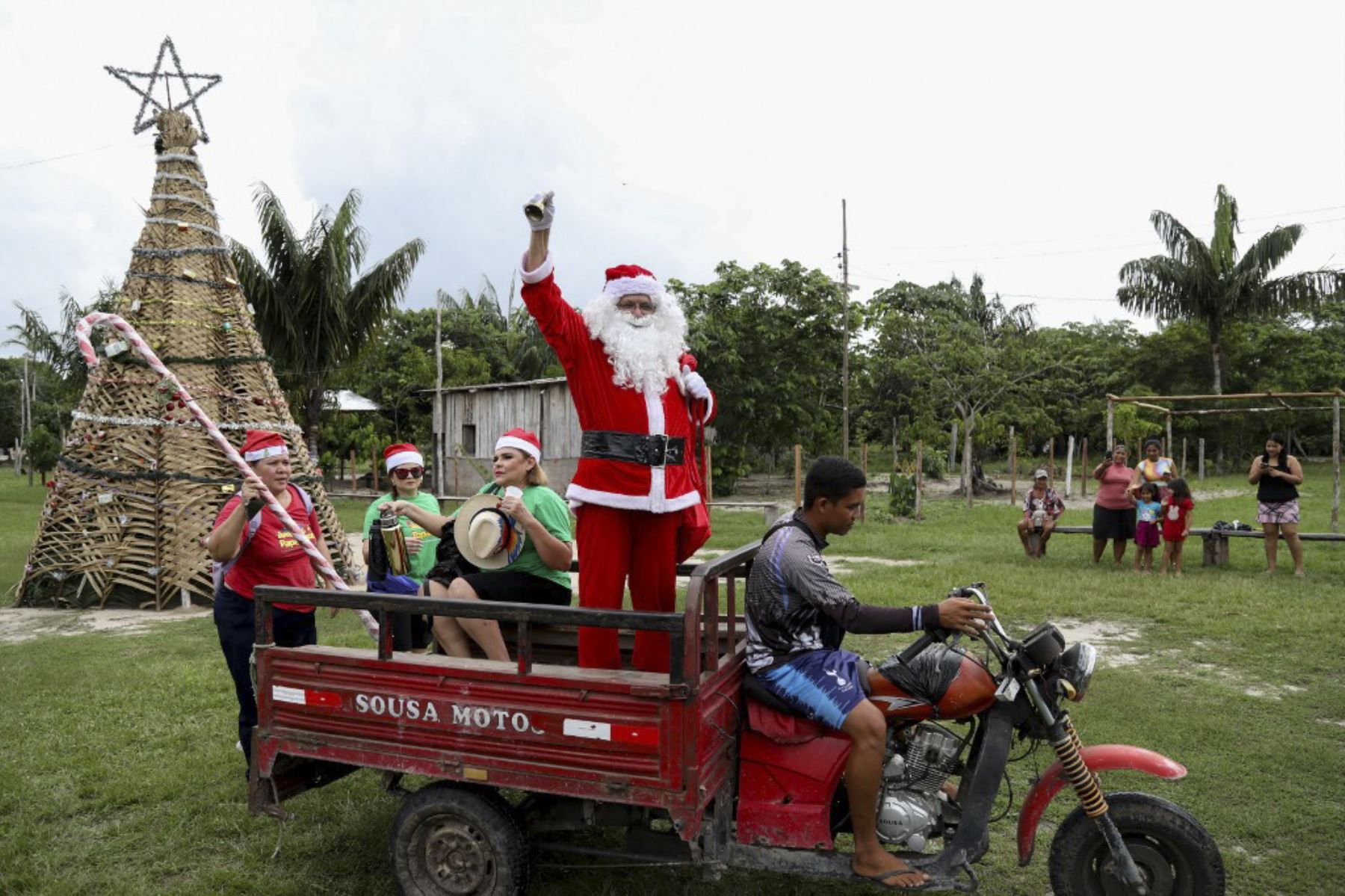 El voluntario Jorge Alberto Barroso, vestido de Papá Noel, es transportado en triciclo para entregar regalos a los niños en la comunidad ribereña de Abelha, en la ciudad de Manaus, estado de Amazonas, norte de Brasil, el 20 de diciembre de 2024. Desde 1998, el grupo "Amigos de Papá Noel" ha estado promoviendo la Navidad para los niños en las comunidades rurales y ribereñas de la selva amazónica. (Foto de MICHAEL DANTAS / AFP)