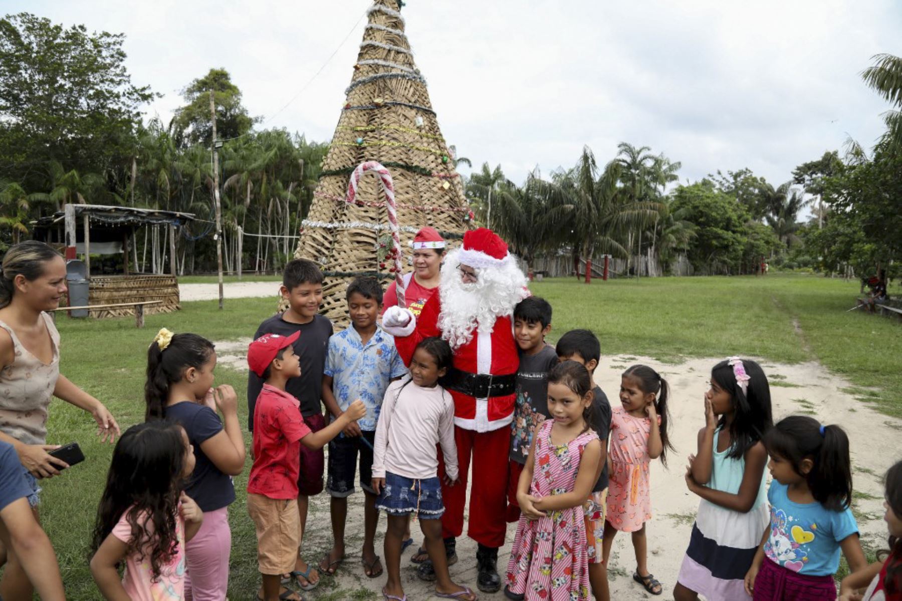 El voluntario Jorge Alberto Barroso, vestido de Papá Noel, es bienvenido a su llegada para entregar regalos a los niños en la comunidad ribereña de Abelha, en la ciudad de Manaos, estado de Amazonas, norte de Brasil, el 20 de diciembre de 2024. Desde 1998, el grupo "Amigos de Papá Noel" ha estado promoviendo la Navidad para los niños en las comunidades rurales y ribereñas de la selva amazónica. (Foto de MICHAEL DANTAS / AFP)