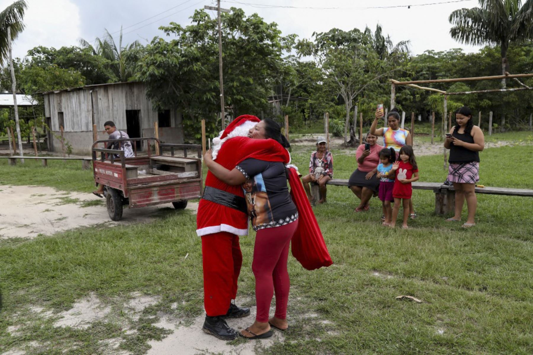 El voluntario Jorge Alberto Barroso, vestido de Papá Noel, es bienvenido a su llegada para entregar regalos a los niños en la comunidad ribereña de Abelha, en la ciudad de Manaos, estado de Amazonas, norte de Brasil, el 20 de diciembre de 2024. Desde 1998, el grupo "Amigos de Papá Noel" ha estado promoviendo la Navidad para los niños en las comunidades rurales y ribereñas de la selva amazónica. (Foto de MICHAEL DANTAS / AFP)