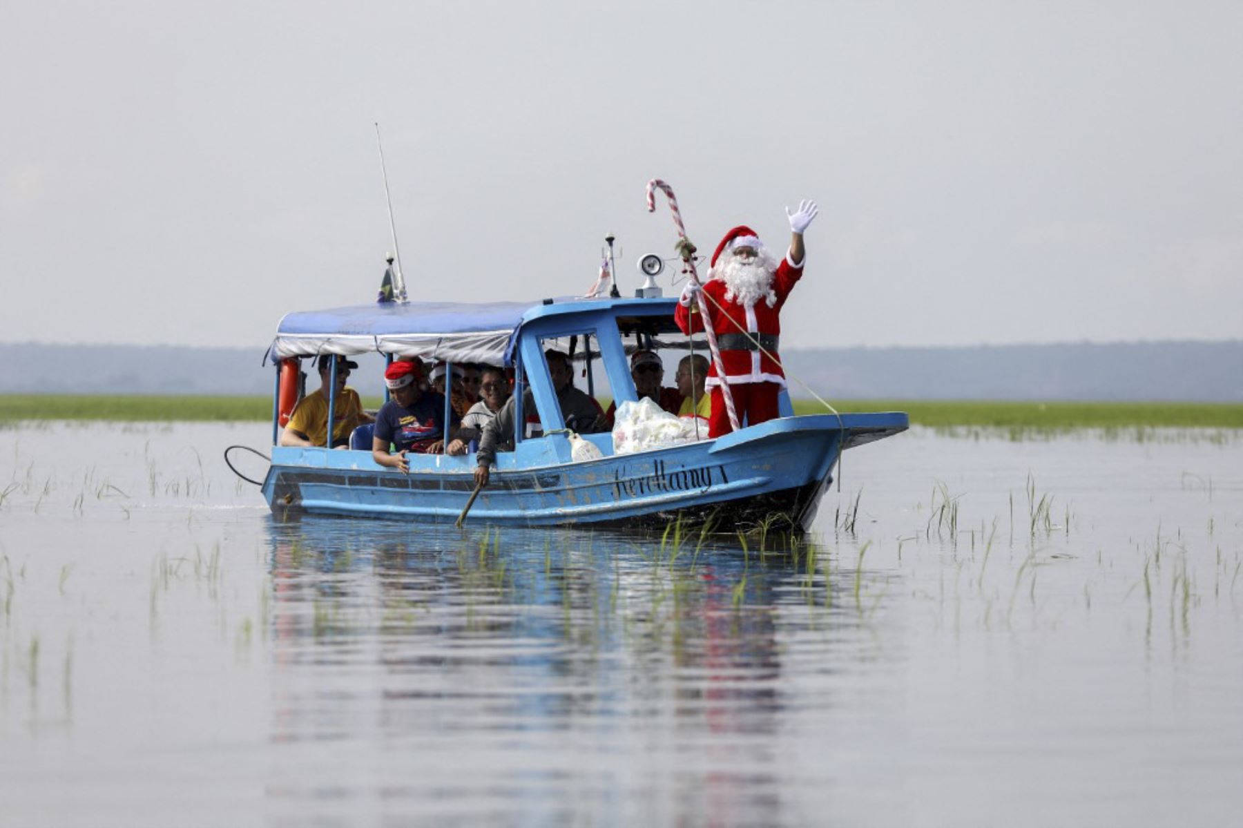 El voluntario Jorge Alberto Barroso, vestido de Papá Noel, navega por el Río Negro para entregar regalos a los niños en la comunidad ribereña de Abelha, en la ciudad de Manaos, estado de Amazonas, norte de Brasil, el 20 de diciembre de 2024. Desde 1998, el grupo "Amigos de Papá Noel" ha estado promoviendo la Navidad para los niños en las comunidades rurales y ribereñas de la selva amazónica. (Foto de MICHAEL DANTAS / AFP)