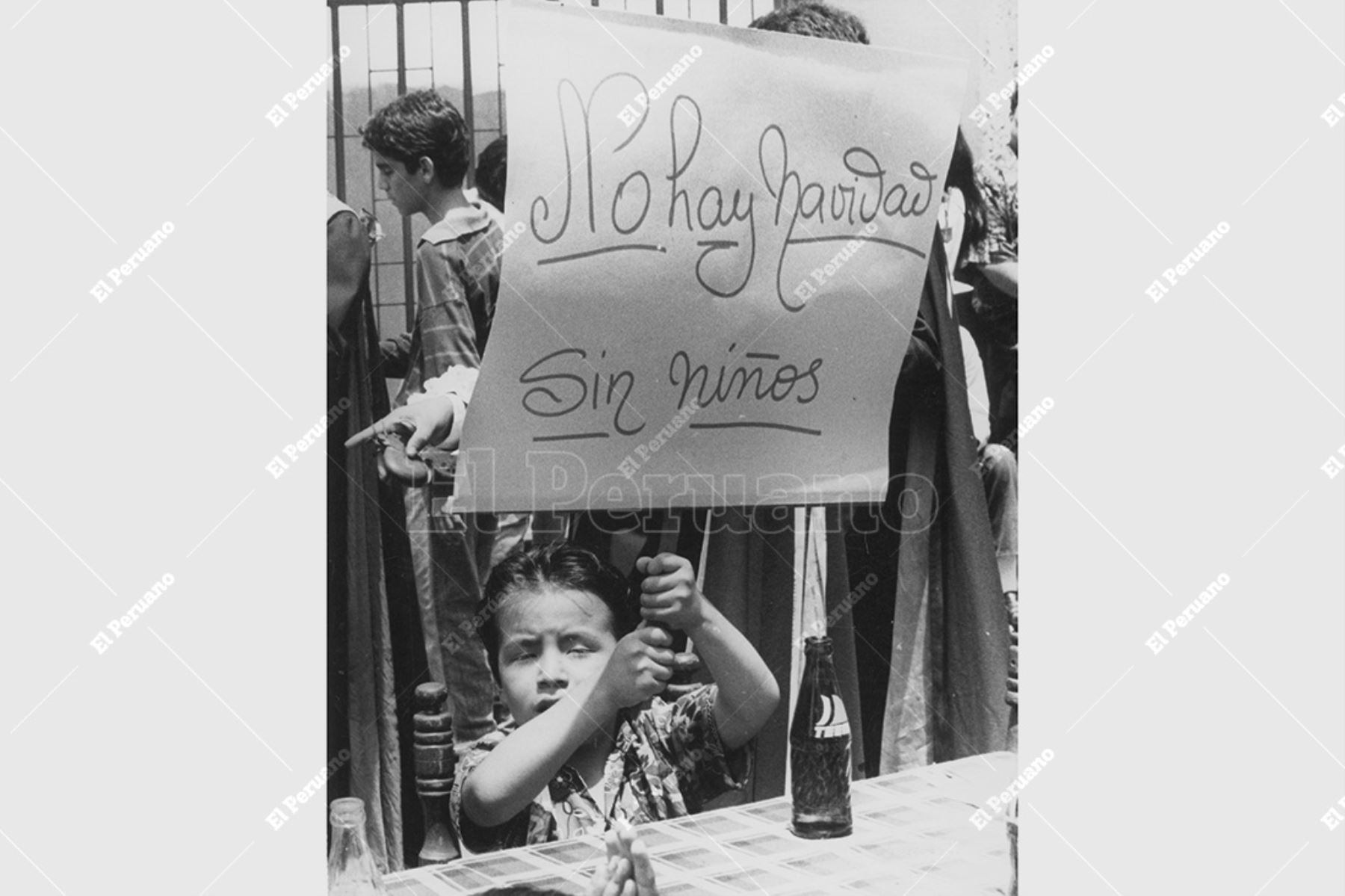 Lima - 15 diciembre 1992 / Un niño sostiene un cartel durante un agasajo por Navidad en Miraflores. Foto: Archivo Histórico de El Peruano / Rómulo Luján