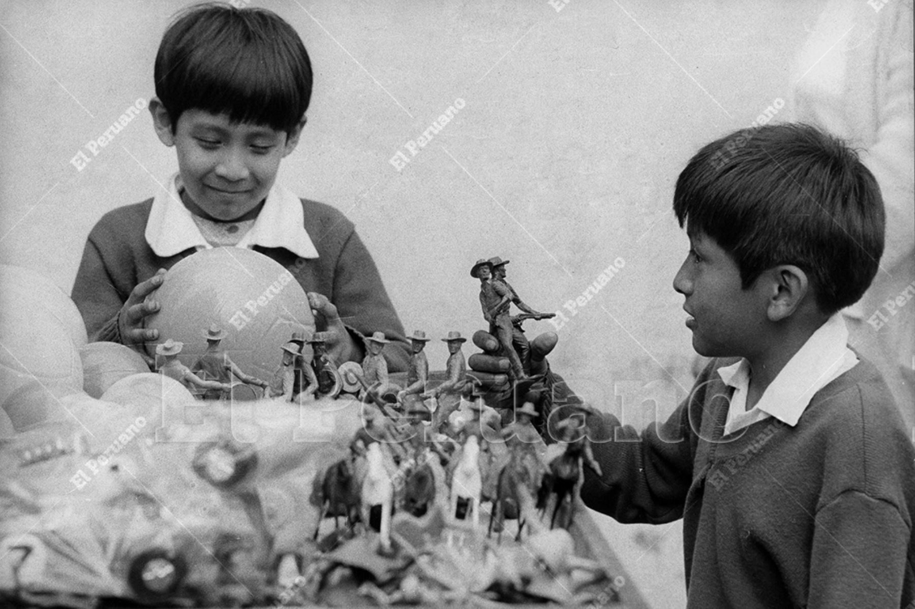 Lima - 5 diciembre 1977 / Dos niños juegan con una pelota y soldaditos de plástico. Vendedores ambulantes ya ofrecen gran variedad de juguetes por Navidad. Foto: Diario Oficial El Peruano / Norman Córdova