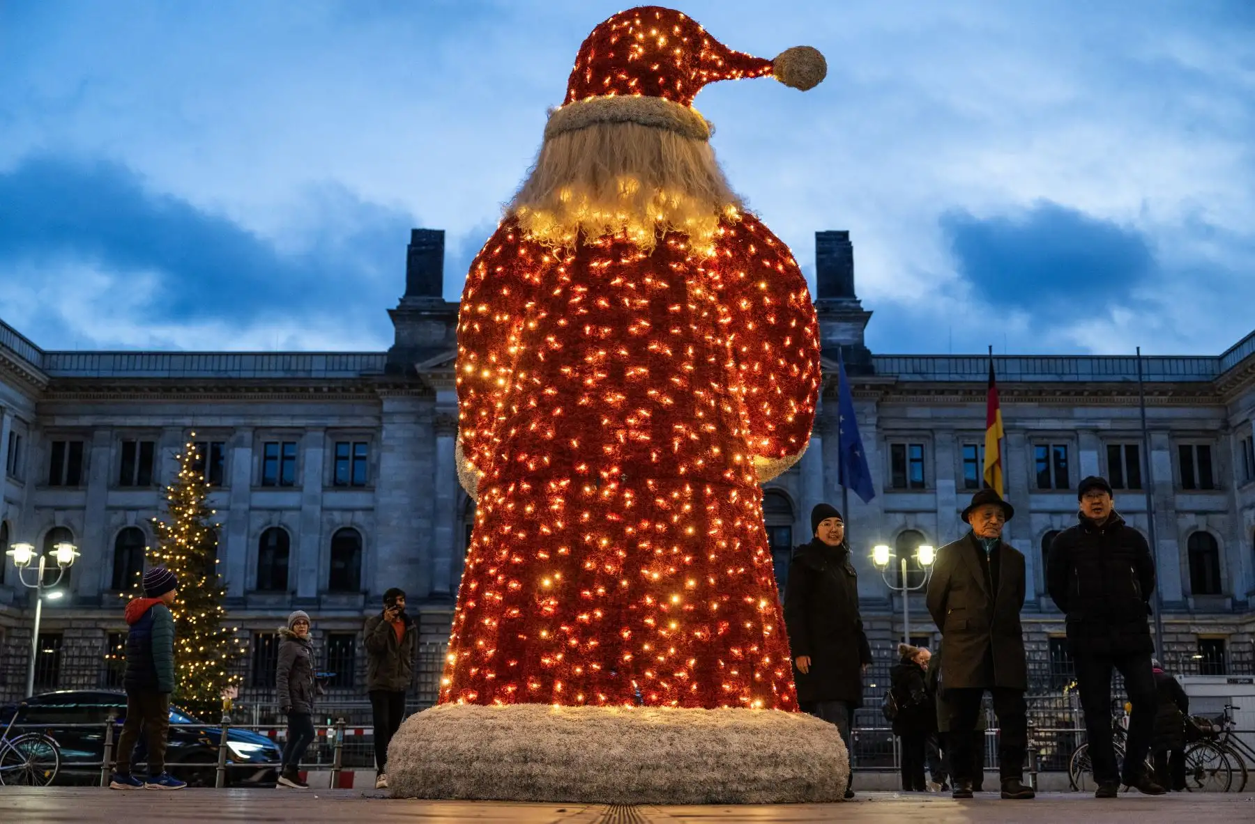 Los peatones pasan junto a una figura gigante de Papá Noel expuesta en un centro comercial de Berlín. Foto: AFP