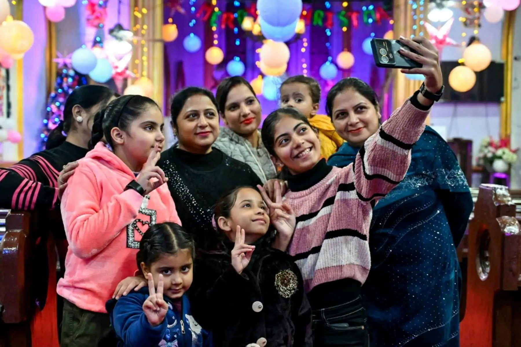 Los devotos cristianos se toman una selfie en vísperas de las celebraciones del día de Navidad, en una iglesia en Amritsar, India. Foto: AFP