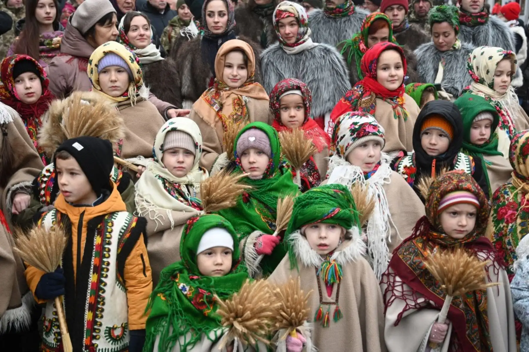 Niños vestidos con ropas tradicionales portan un 