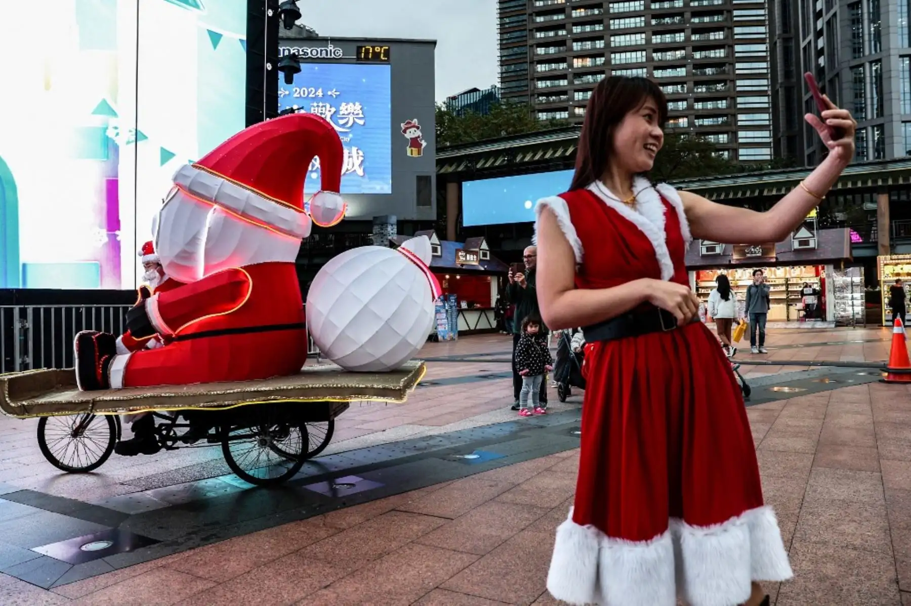 Una mujer vestida como Papá Noel se toma una selfie durante el New Taipei Christmasland 2024 en la víspera de Navidad en la ciudad de New Taipei, Taiwán. Foto: AFP
