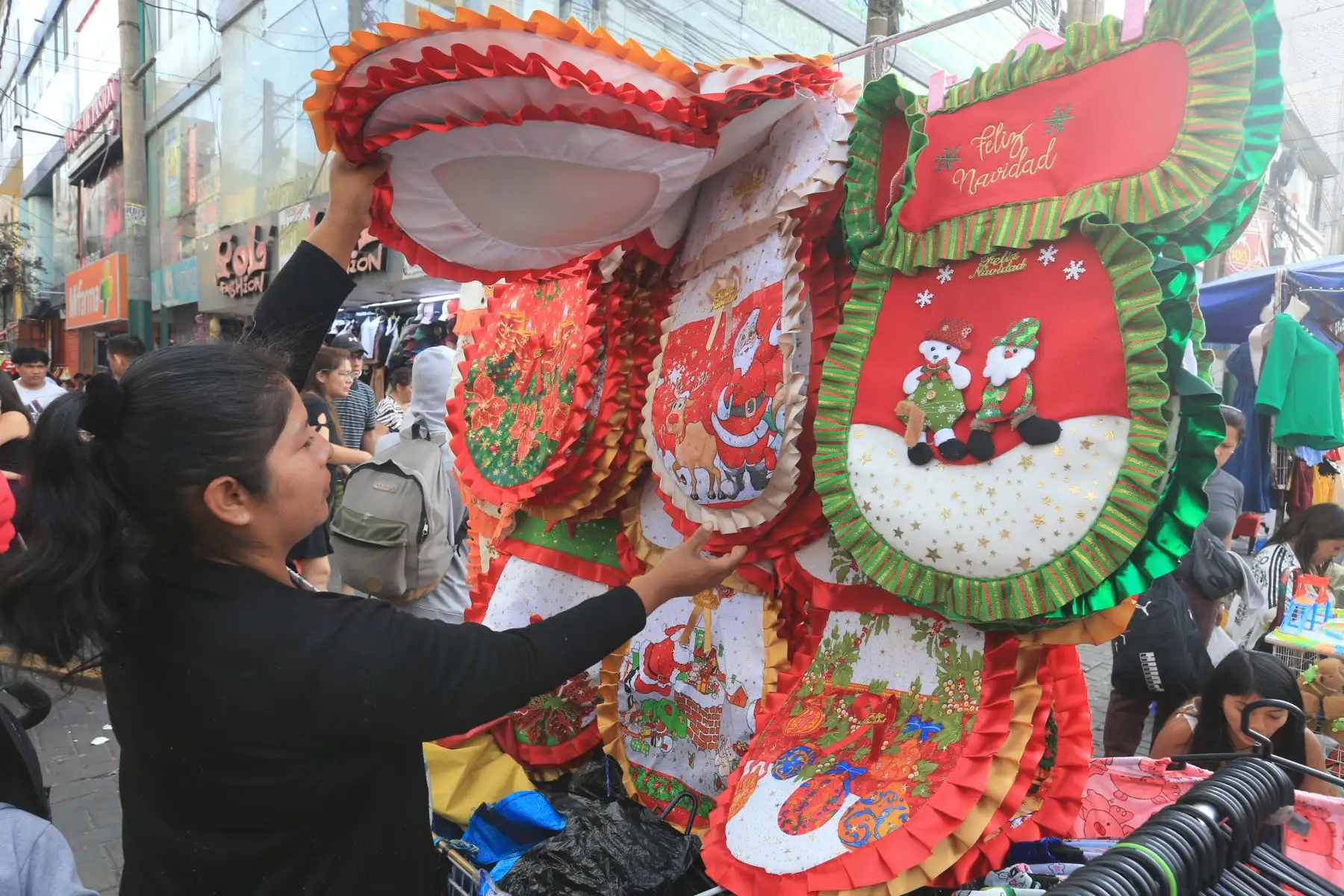 Centenares de personas acuden este martes 24 al emporio textil y de confecciones de Gamarra, en el distrito de La Victoria, para hacer las últimas compras navideñas. Fotos: ANDINA/Héctor Vinces