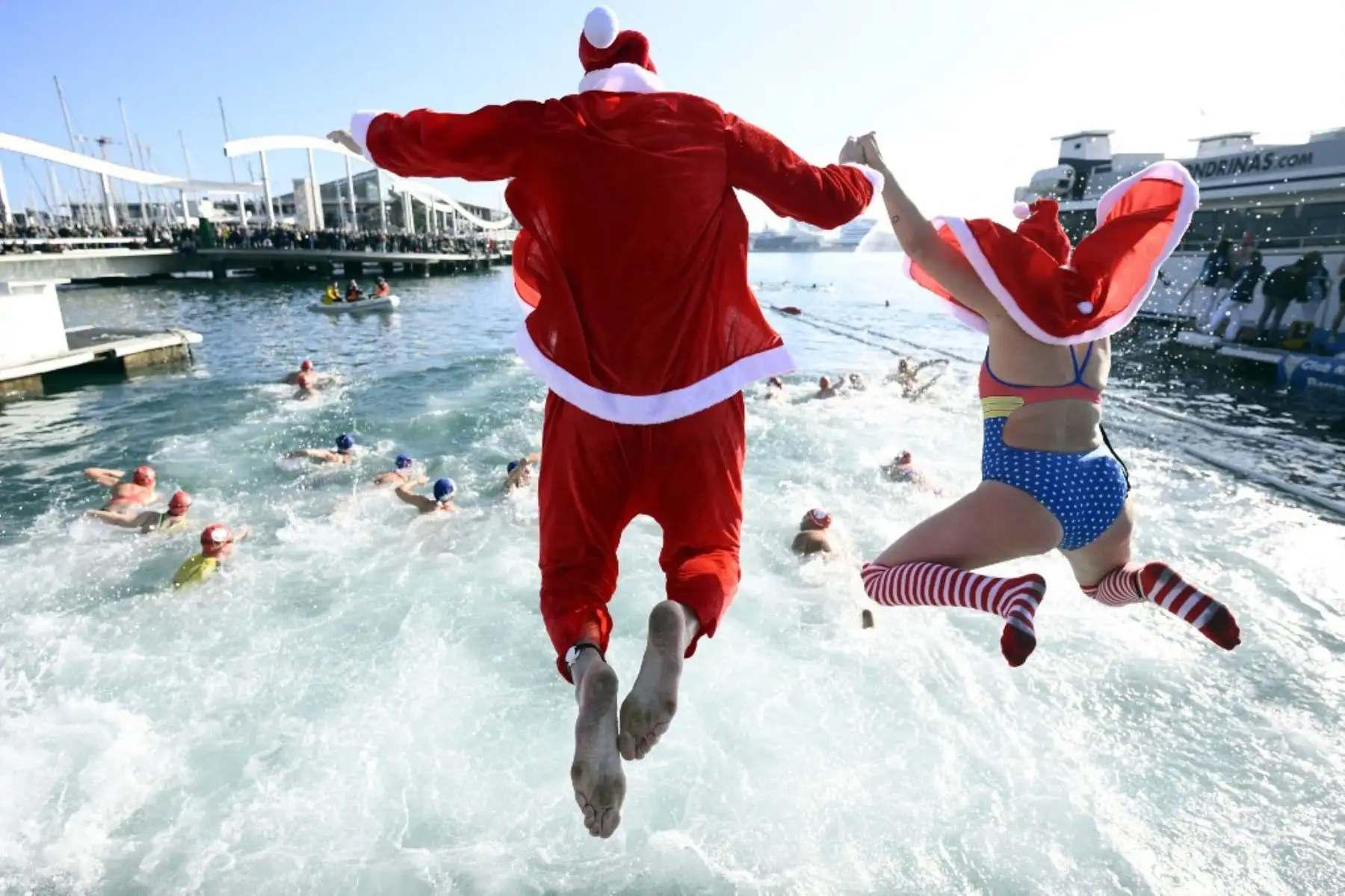 Participantes disfrazados de Papá Noel saltan al agua durante la 115ª edición de la carrera de natación Copa Nadal (Copa de Navidad) en el Port Vell de Barcelona el 25 de diciembre de 2024. La tradicional carrera de natación navideña de 200 metros reunió a más de 450 participantes en el Port Vell de Barcelona

Foto: AFP