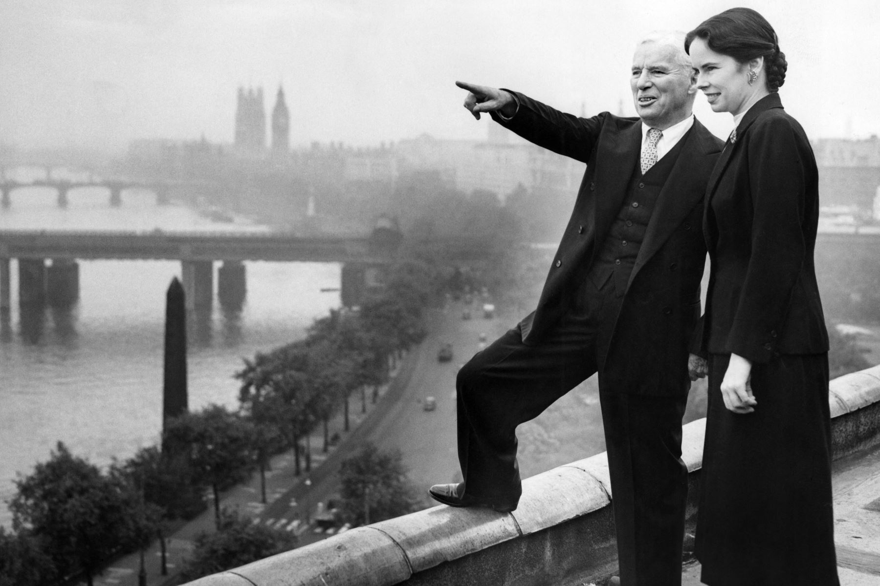 El director de cine y actor británico Charlie Chaplin, que ha regresado a su ciudad natal de Londres, señala a su esposa Oona Chaplin algunos de los lugares emblemáticos de Londres desde la azotea del Hotel Savoy el 23 de septiembre de 1952.
Foto: AFP