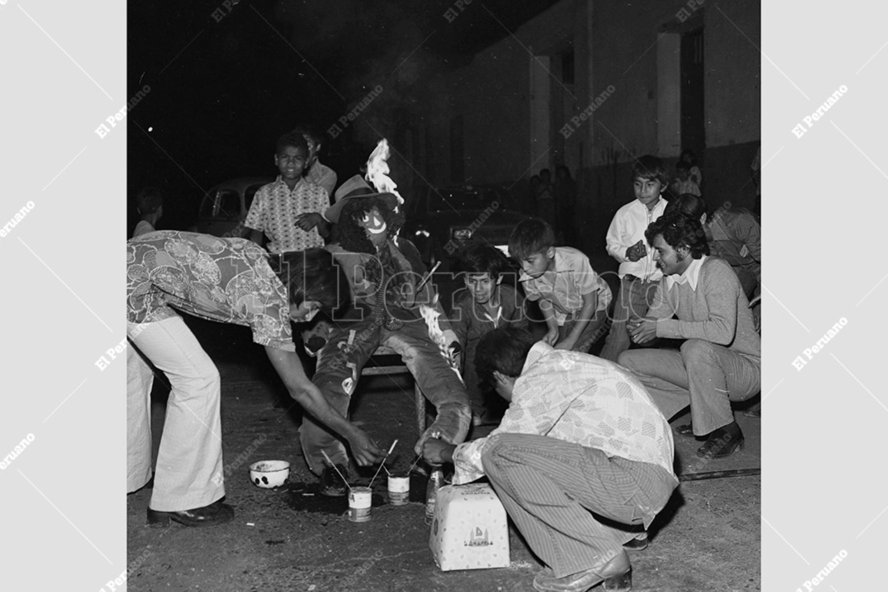 Lima - 1 enero 1975 / Preciso instante en el que dos jóvenes encienden el tradicional muñeco ante la entusiasta mirada de un grupo de niños  para celebrar así el fin del año 1974 y el comienzo del Año Nuevo. Foto: Diario Oficial El Peruano / Raúl Sagástegui