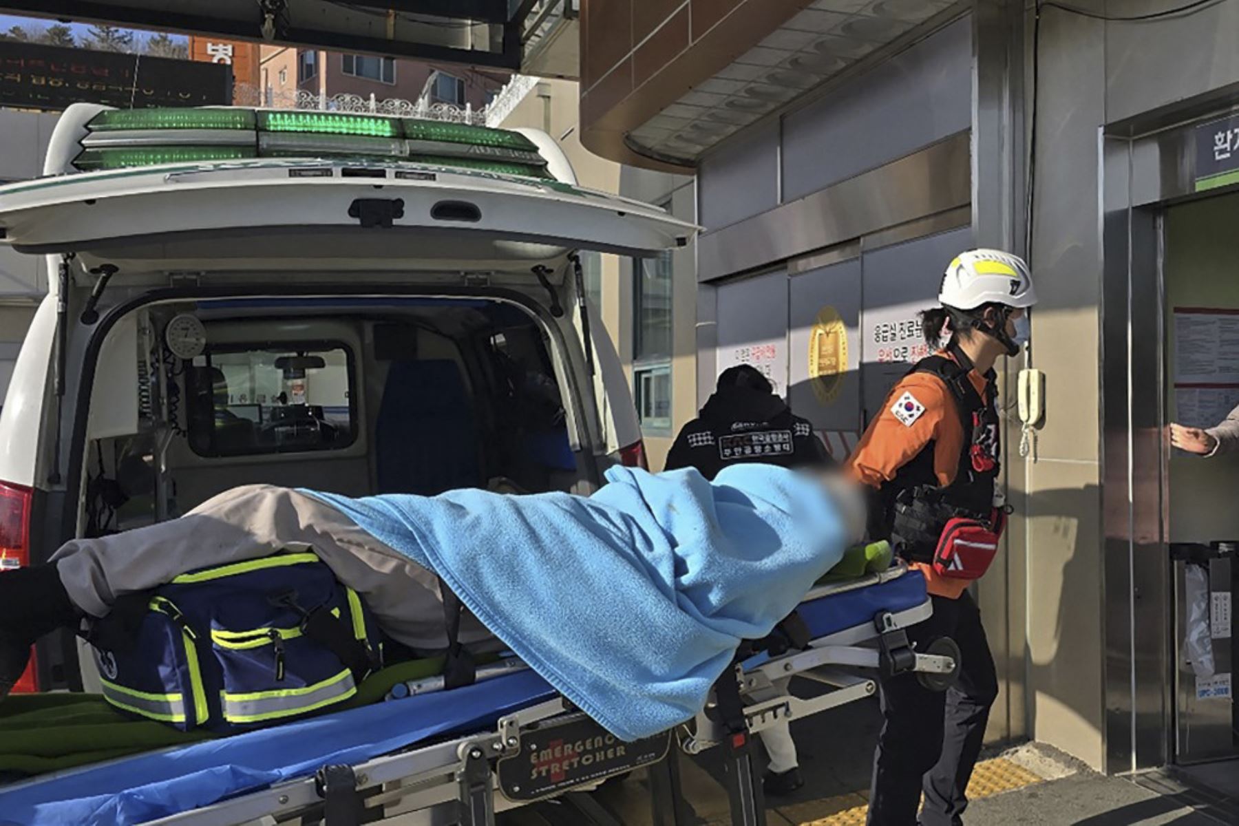 Un pasajero (cara digitalmente borrosa en la fuente) es trasladado de una ambulancia a un centro médico tras el accidente de un avión de la serie Boeing 737-800 de Jeju Air en el Aeropuerto Internacional de Muan en la provincia del Sur de Jeolla, a unos 288 kilómetros al suroeste de Seúl el 29 de diciembre de 2024. Un avión de Jeju Air que transportaba a 181 personas de Bangkok a Corea del Sur se estrelló al llegar el 29 de diciembre, las autoridades dijeron a la AFP, con 29 muertos confirmados y un video d