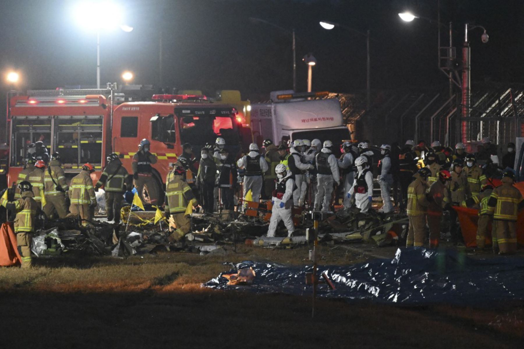 Los bomberos y el personal de rescate trabajan cerca de la escena donde un avión de la serie Boeing 737-800 de Jeju Air se estrelló y se incendió en el Aeropuerto Internacional de Muan, en la provincia de South Jeolla, a unos 288 kilómetros al suroeste de Seúl, el 29 de diciembre de 2024. Un avión de Jeju Air que transportaba a 181 personas de Tailandia a Corea del Sur se estrelló al llegar, estrellando contra una barrera y estallando en llamas, dejando a todos menos a dos temidos muertos. (Foto de JUNG YEO