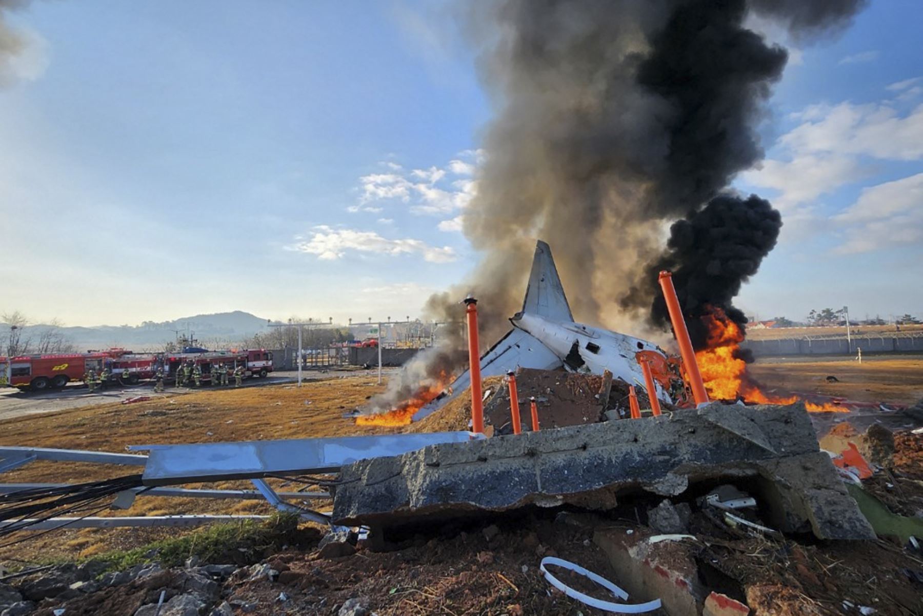 El fuego y el humo se elevan desde la sección de cola de un avión de la serie Jeju Air Boeing 737-800 después de que el avión se estrellara y estallara en llamas en el Aeropuerto Internacional de Muan en la provincia de South Jeolla, a unos 288 kilómetros al suroeste de Seúl el 29 de diciembre de 2024. Foto: AFP