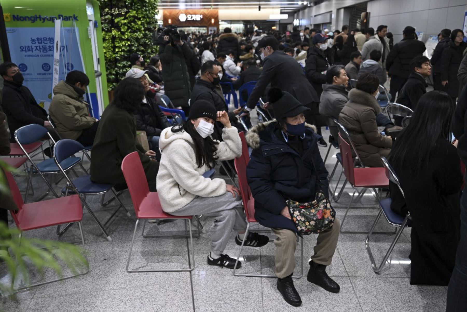 Las personas y familiares de los pasajeros del avión estrellado de la serie Boeing 737-800 de Jeju Air reaccionan en el Aeropuerto Internacional de Muan, en la provincia del Sur de Jeolla, a unos 288 kilómetros al suroeste de Seúl, el 29 de diciembre de 2024. Un avión de Jeju Air que transportaba a 181 personas de Tailandia a Corea del Sur se estrelló al llegar, estrellando contra una barrera y estallando en llamas, dejando a todos menos a dos temidos muertos. (Foto de JUNG YEON-JE / AFP)