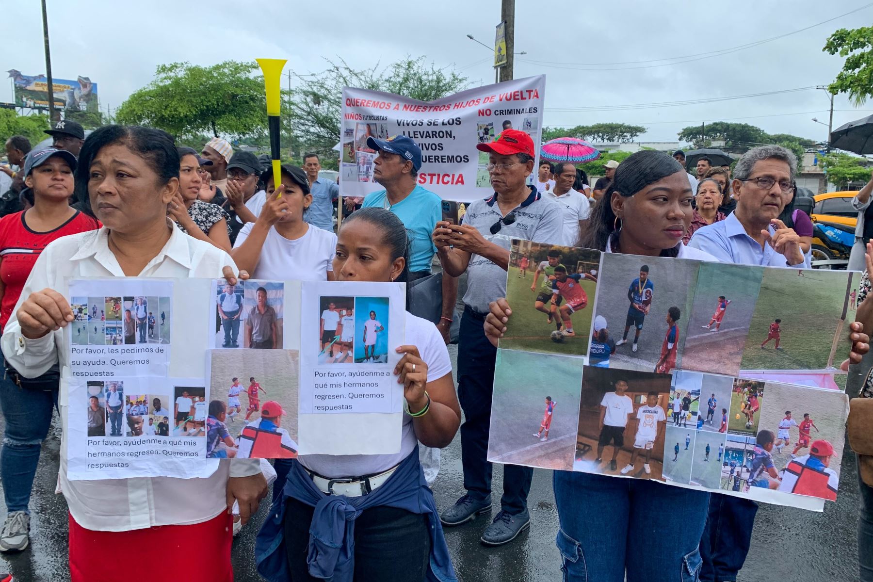 Familiares de los cuatro menores desaparecidos sostienen carteles durante un plantón en los exteriores de la Fiscalía de Guayaquil. Foto: EFE