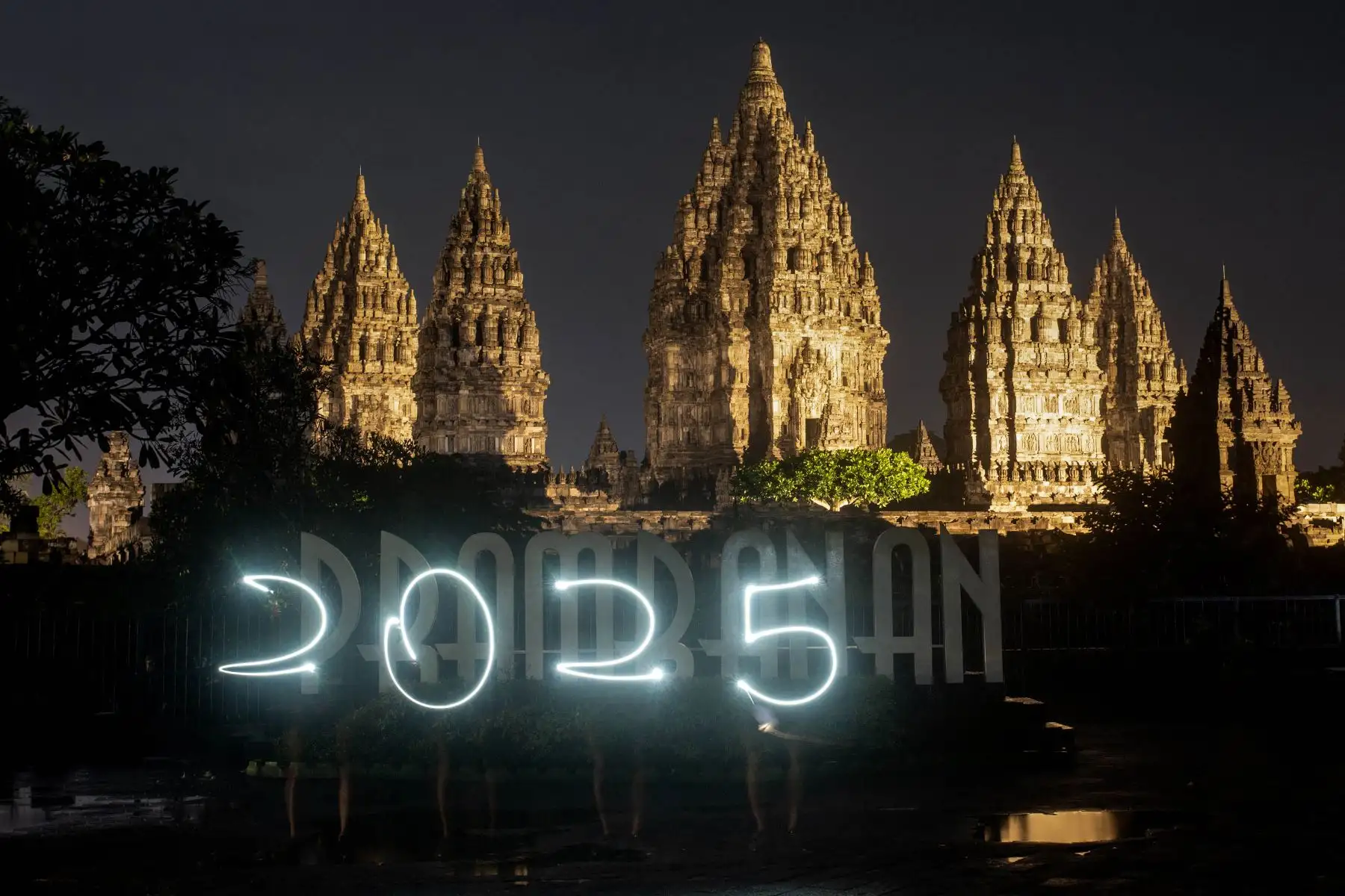 La gente crea un cartel de 2025 mientras esperan los fuegos artificiales de Año Nuevo en el Templo Prambanan, un complejo de templos hindúes del siglo IX y Patrimonio de la Humanidad por la UNESCO, en Yogyakarta.
Foto: AFP