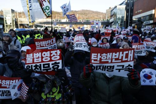 Partidarios de Yoon Suk Yeol protestan frente a agentes anticorrupción y policías que buscan entrar a la residencia presidencial en Seúl. Foto: EFE.