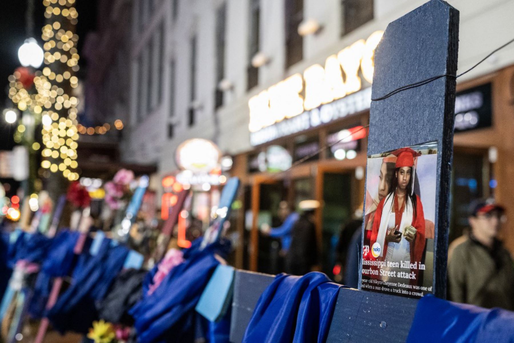 Una cruz con la imagen de la víctima de 18 años NiíKyra Cheyenne Dedeaux se ve en un monumento conmemorativo en Bourbon Street después de que reabriera al público en Nueva Orleans. Foto: AFP