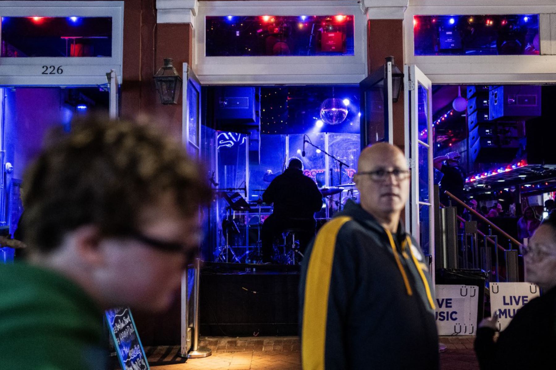 Una banda toca junto a cruces con fotografías de víctimas en un monumento conmemorativo en Bourbon Street después de que reabriera al público, en Nueva Orleans. Foto: AFP