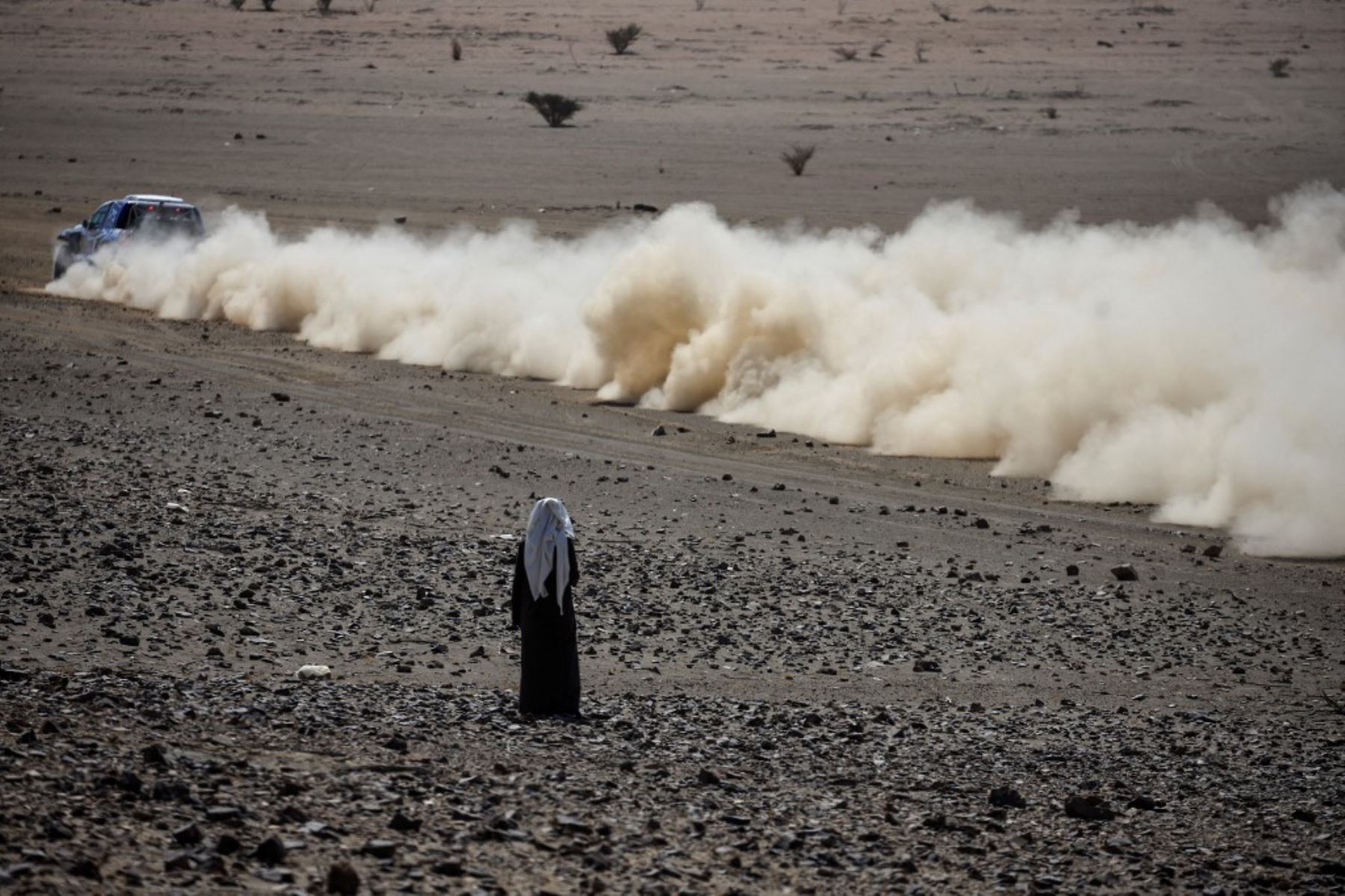 Un residente local del desierto observa un automóvil en competencia durante el prólogo del 47º Rally Dakar, en Bisha, Arabia Saudita, el 3 de enero de 2025. Foto: AFP